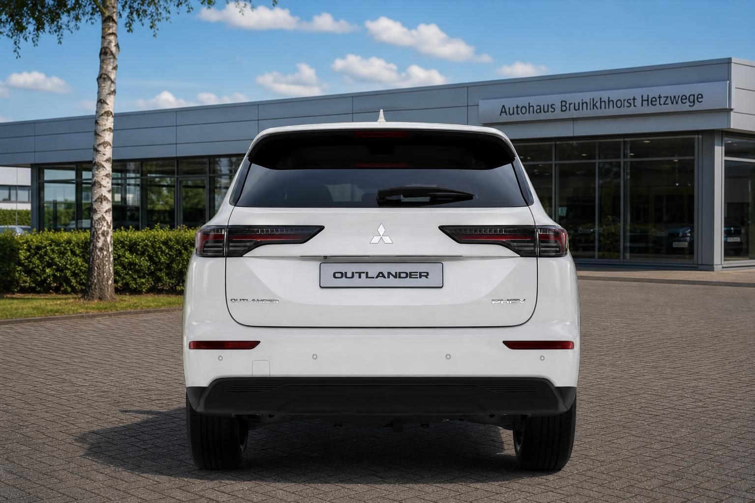 Mitsubishi Outlander PHEV weiß Heckansicht vor Autohaus Brunkhorst Hetzwege