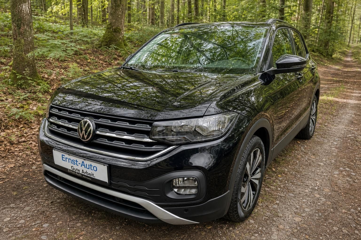 Volkswagen T-Cross SUV in schwarz - Frontansicht mit Kühlergrill und LED-Scheinwerfern im Wald
