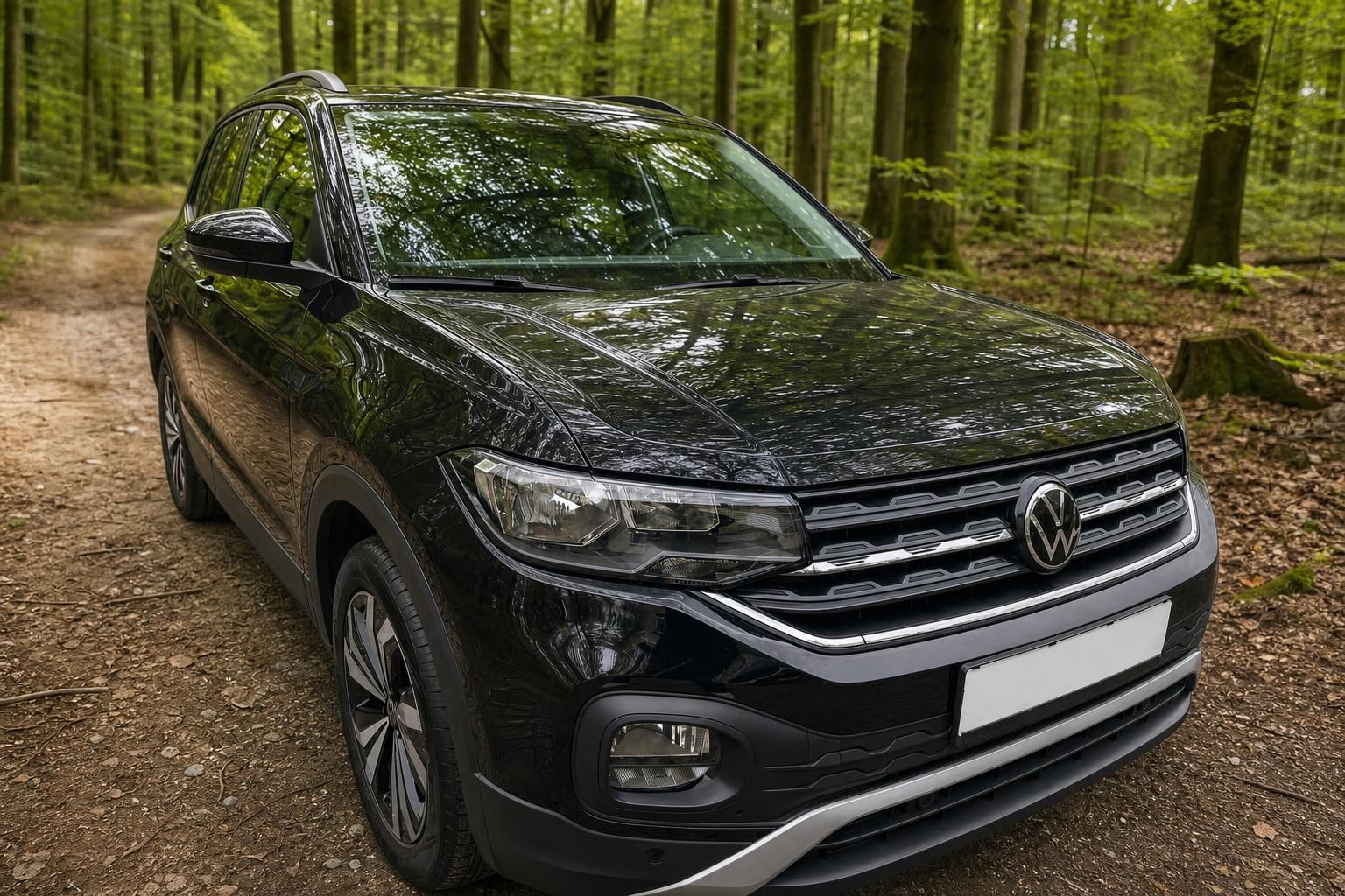 Volkswagen T-Cross in schwarz - Schrägansicht von vorne links mit Alufelgen auf Waldweg