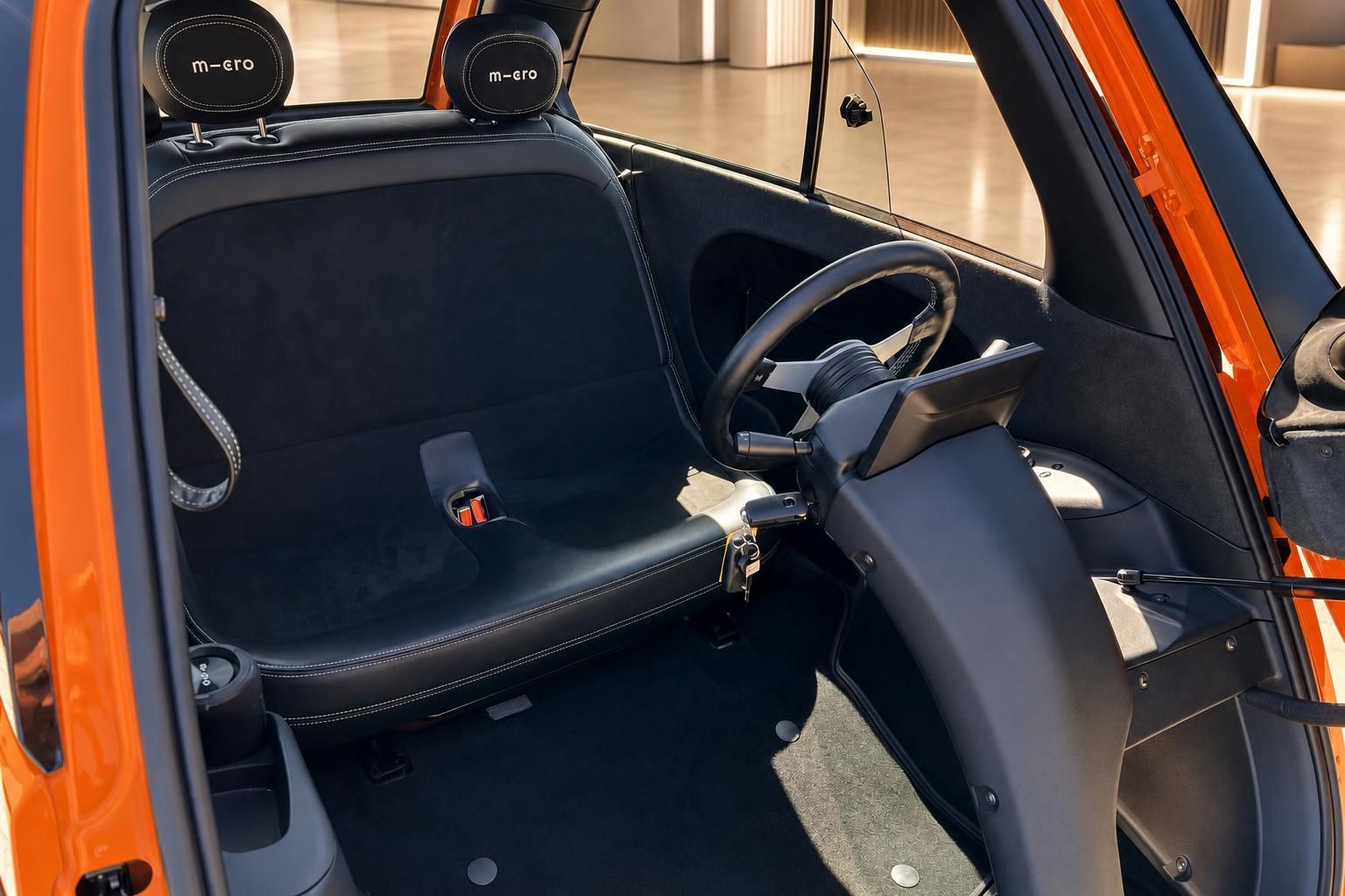 Microlino Fahrgastraum Innenausstattung - schwarze Sitze mit M-Ero Logo und Sicherheitsgurte