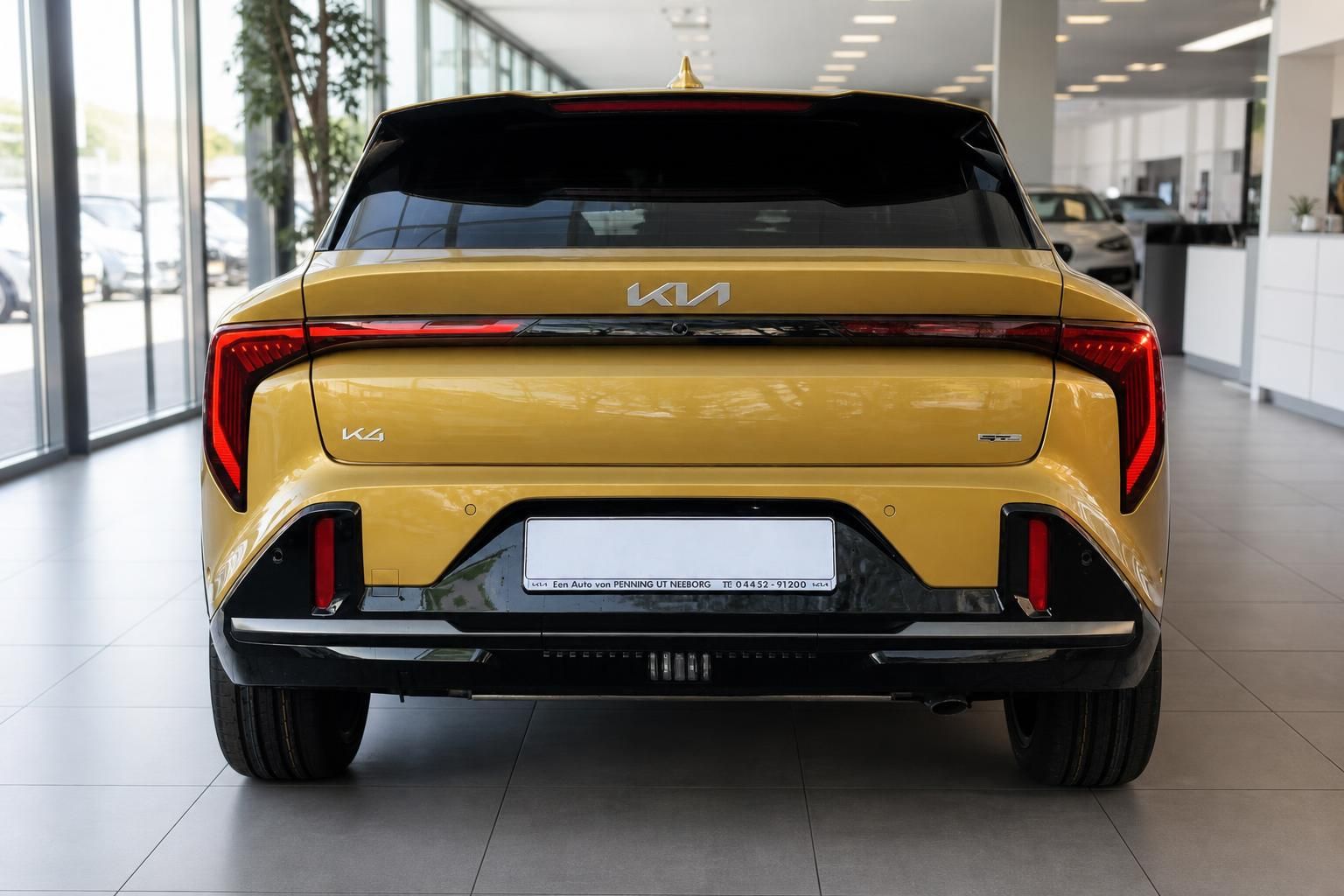Kia K4 GT-Line gelb, direkte Heckansicht im Autohaus