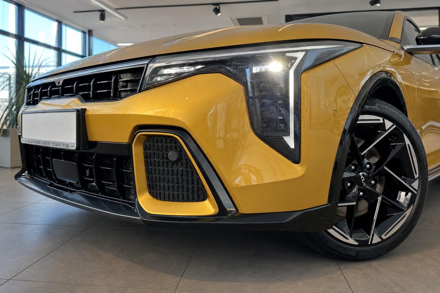 Kia in Gelb: Frontansicht mit LED-Scheinwerfer und Felge im Detail