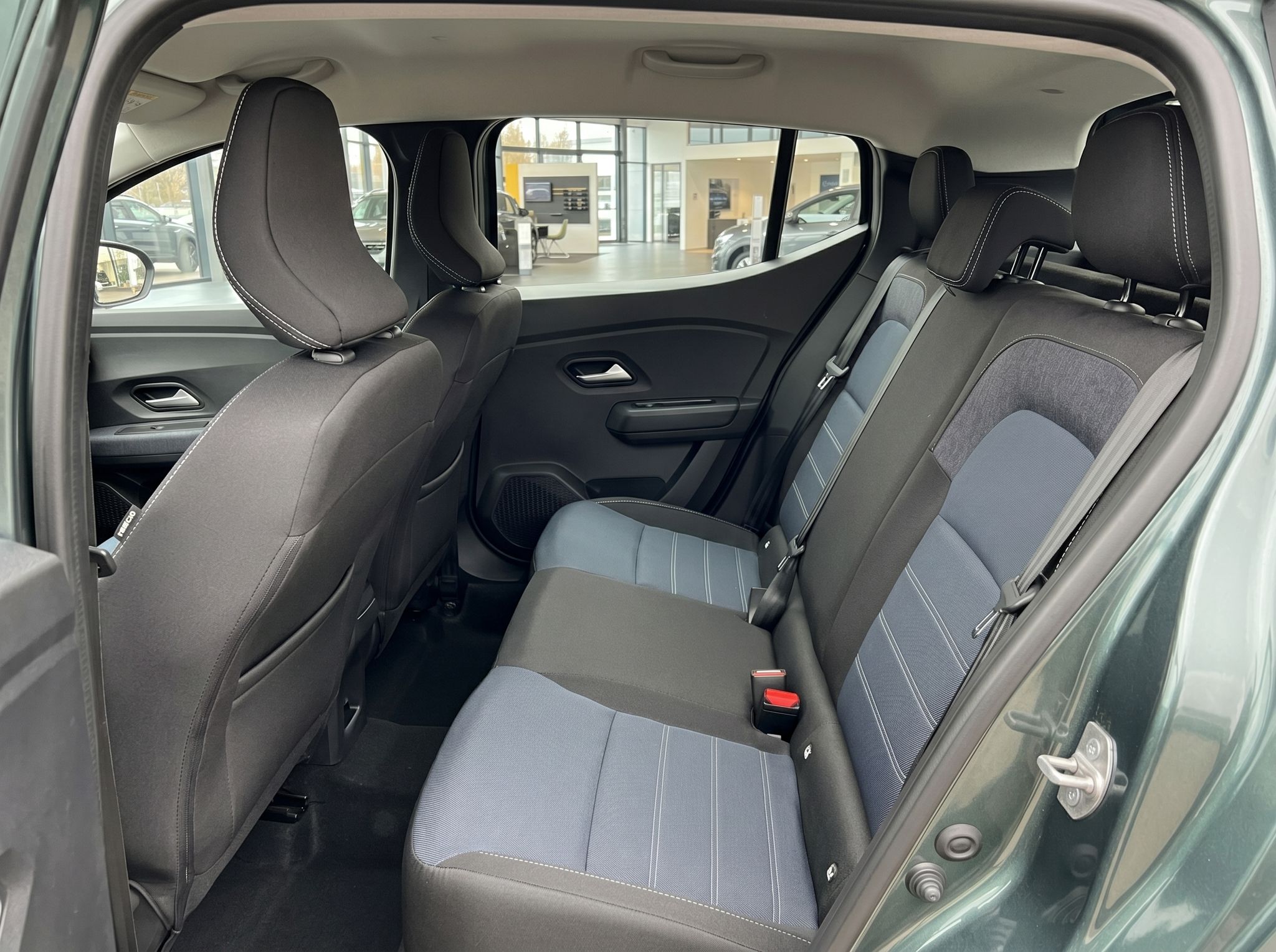 Auto Rückbank mit geteilten Sitzflächen in Schwarz-Grau und Blick durch Heckscheibe