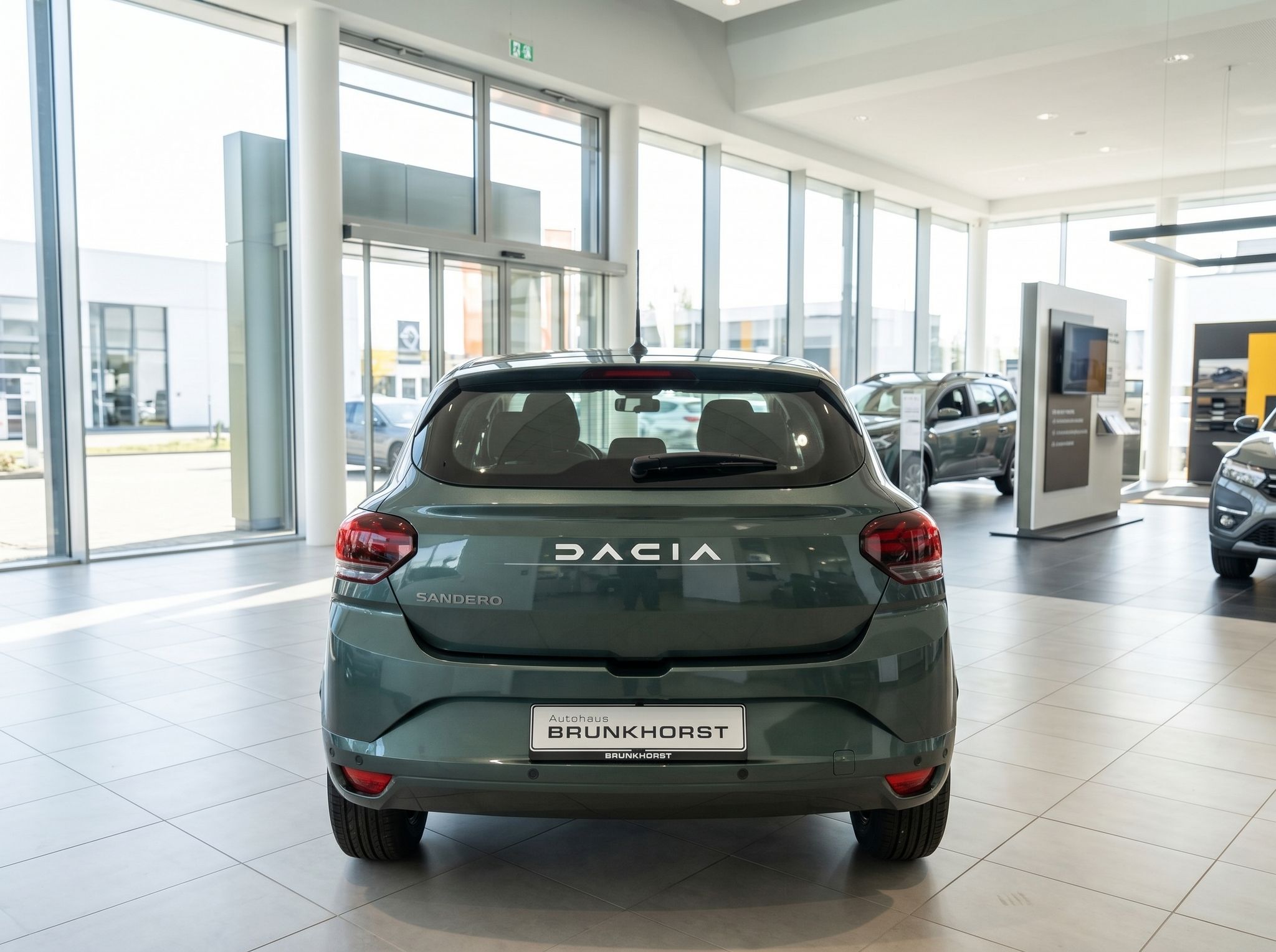 Dacia Sandero grün metallic Heckansicht im Autohaus Showroom mit Brunkhorst Kennzeichen