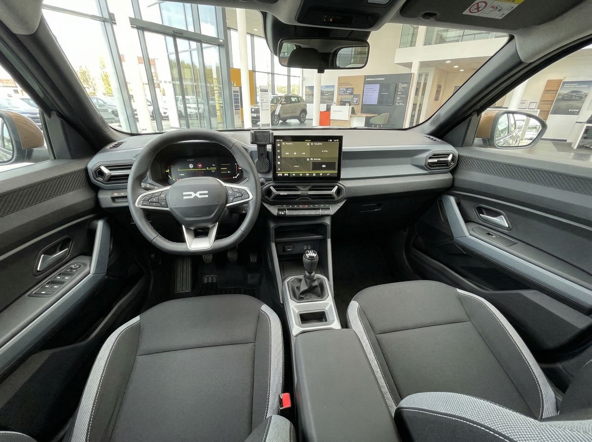 Dacia Innenraum mit modernem Dashboard, Touchscreen und grauen Sitzen
