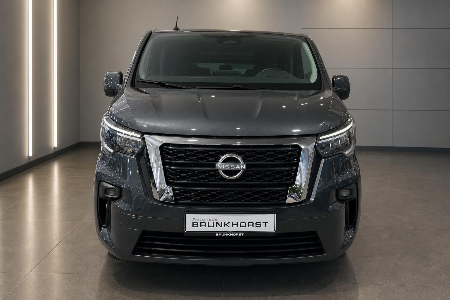 Nissan Primastar Transporter grau von vorne im Showroom - Frontansicht mit Kühlergrill