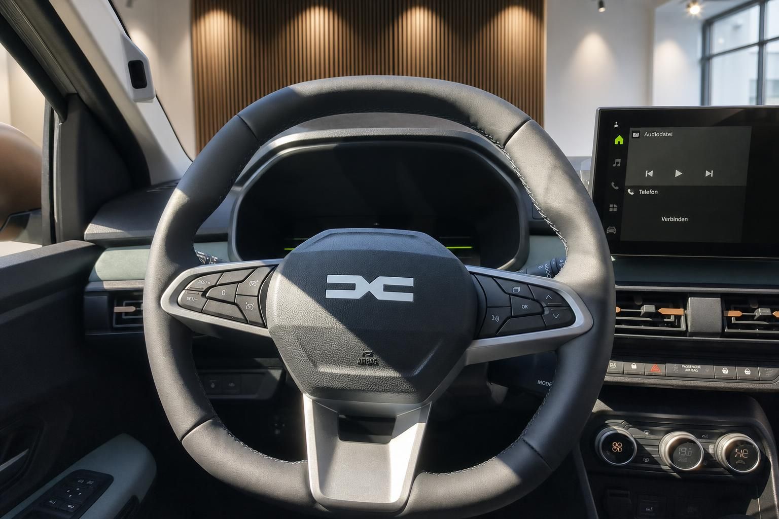 Lenkrad mit Multifunktionstasten und digitalem Cockpit im Fahrzeuginnenraum