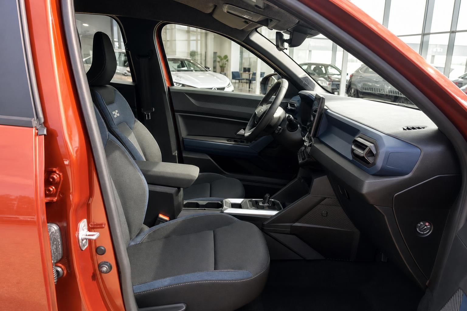 Fahrzeug Innenraum mit grauen Sitzen und orangener Karosserie im Autohaus