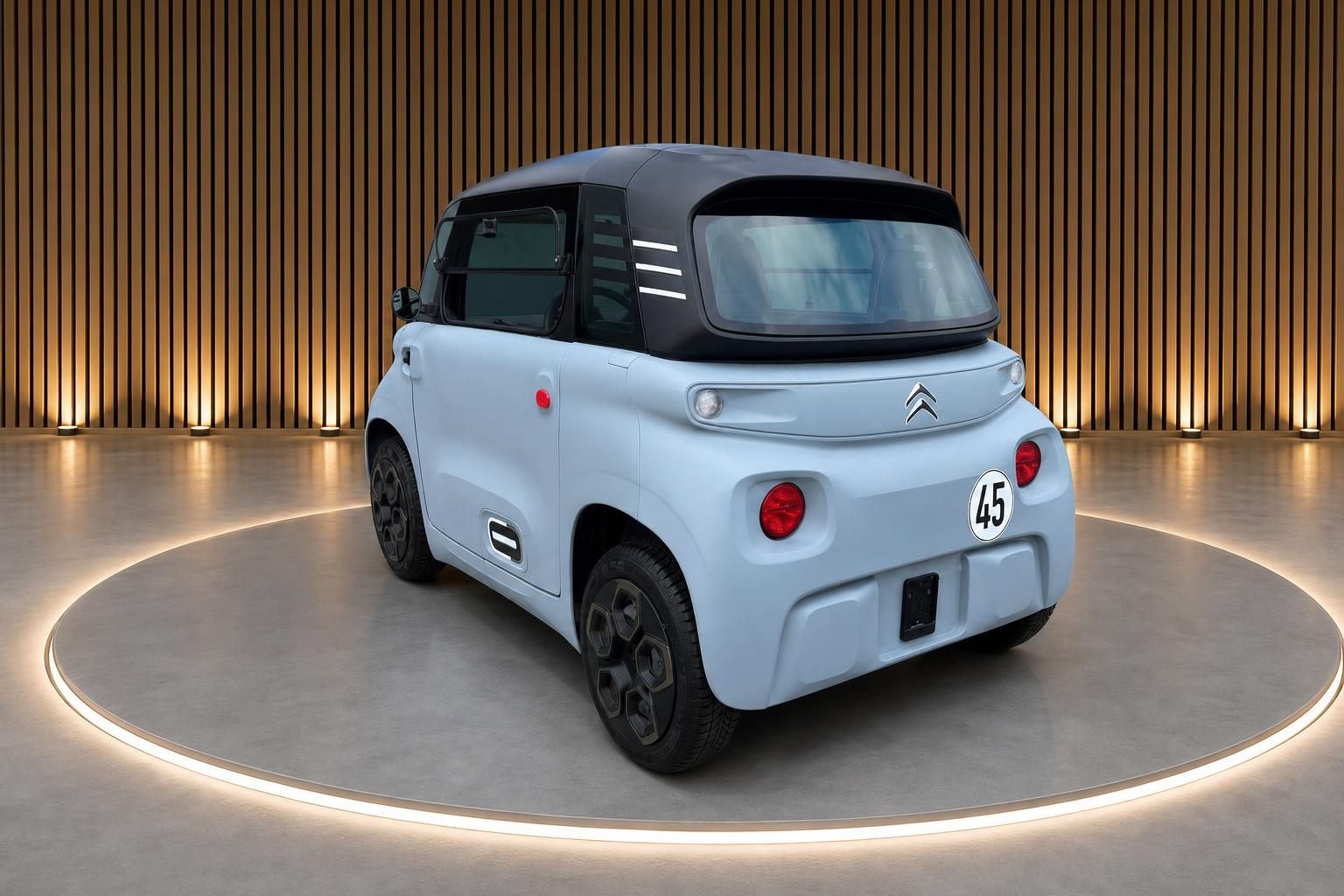 Citroën Ami Elektrofahrzeug Heckansicht Hellblau mit schwarzem Dach im Showroom