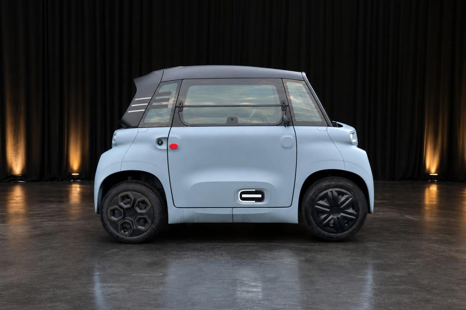 Citroën Ami Elektroauto in Hellblau Seitenansicht vor dunklem Hintergrund
