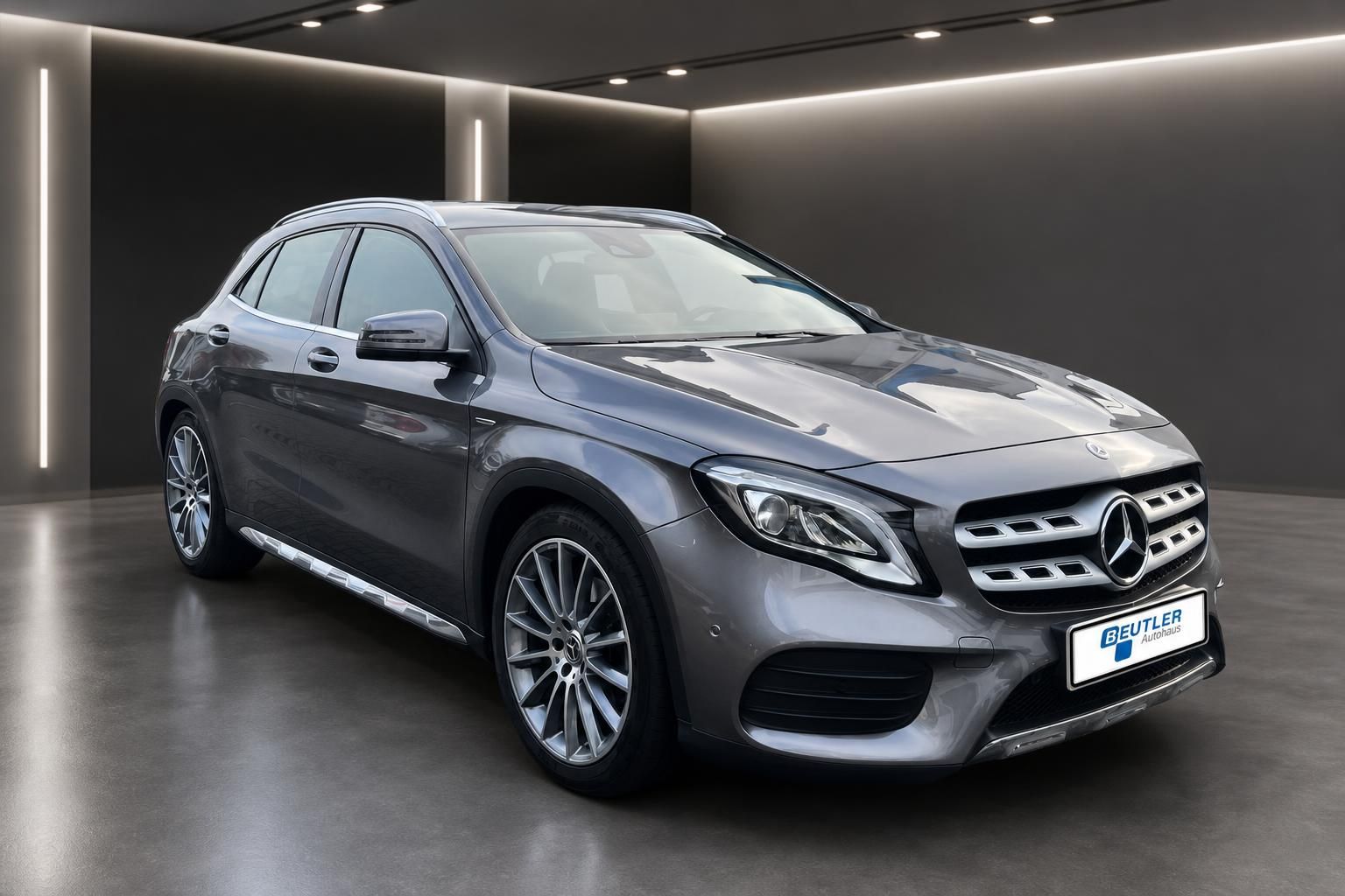 Mercedes-Benz GLA AMG Line grau metallic, Frontansicht seitlich im Showroom