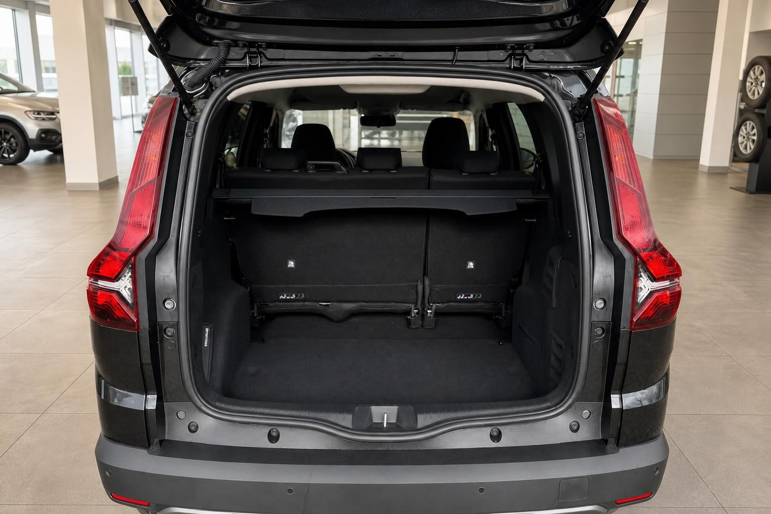 Geöffneter Kofferraum eines grauen SUV mit schwarzer Innenausstattung