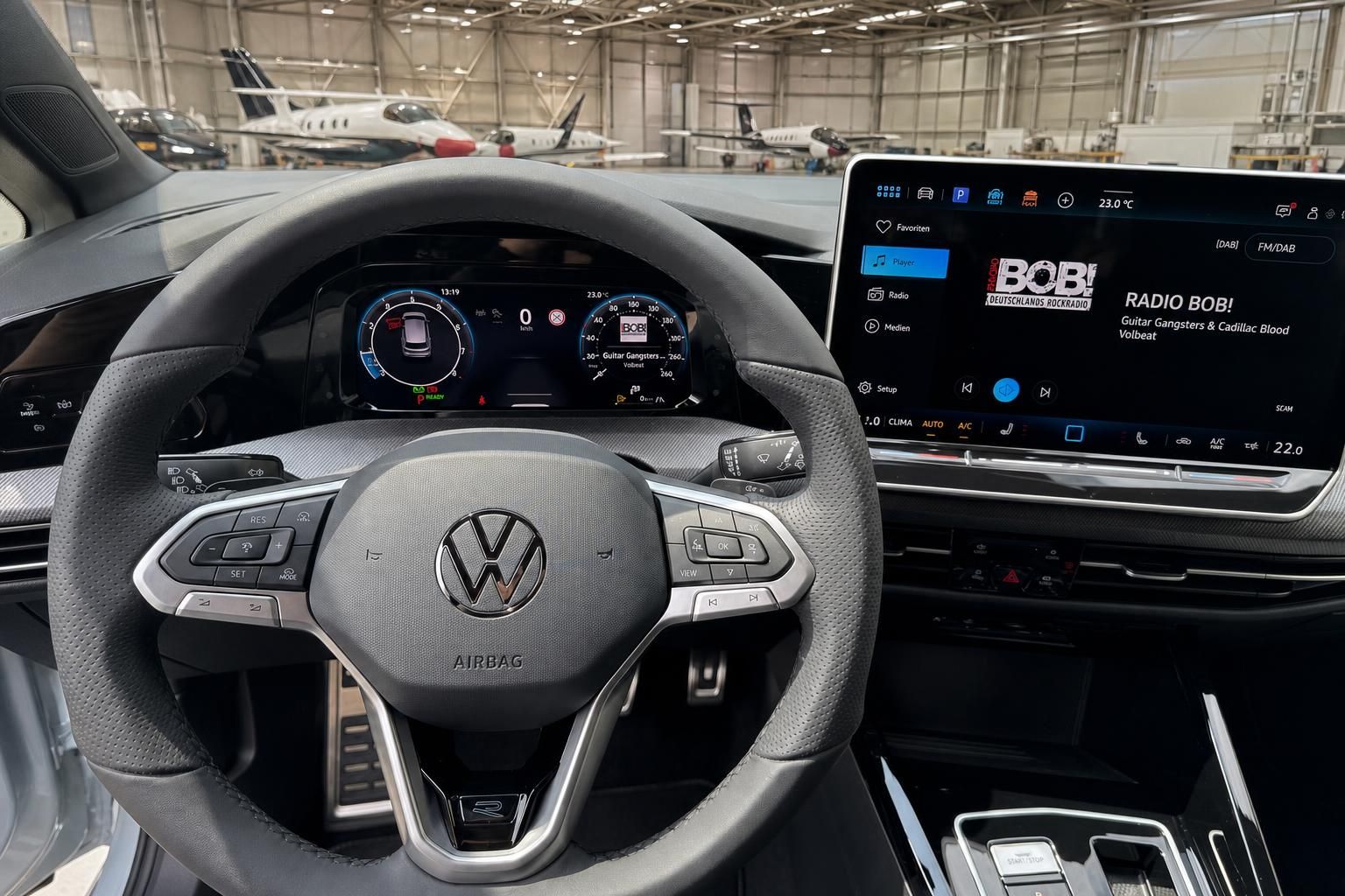 VW Cockpit mit Lenkrad, digitalem Tacho und Infotainment-Display im Hangar