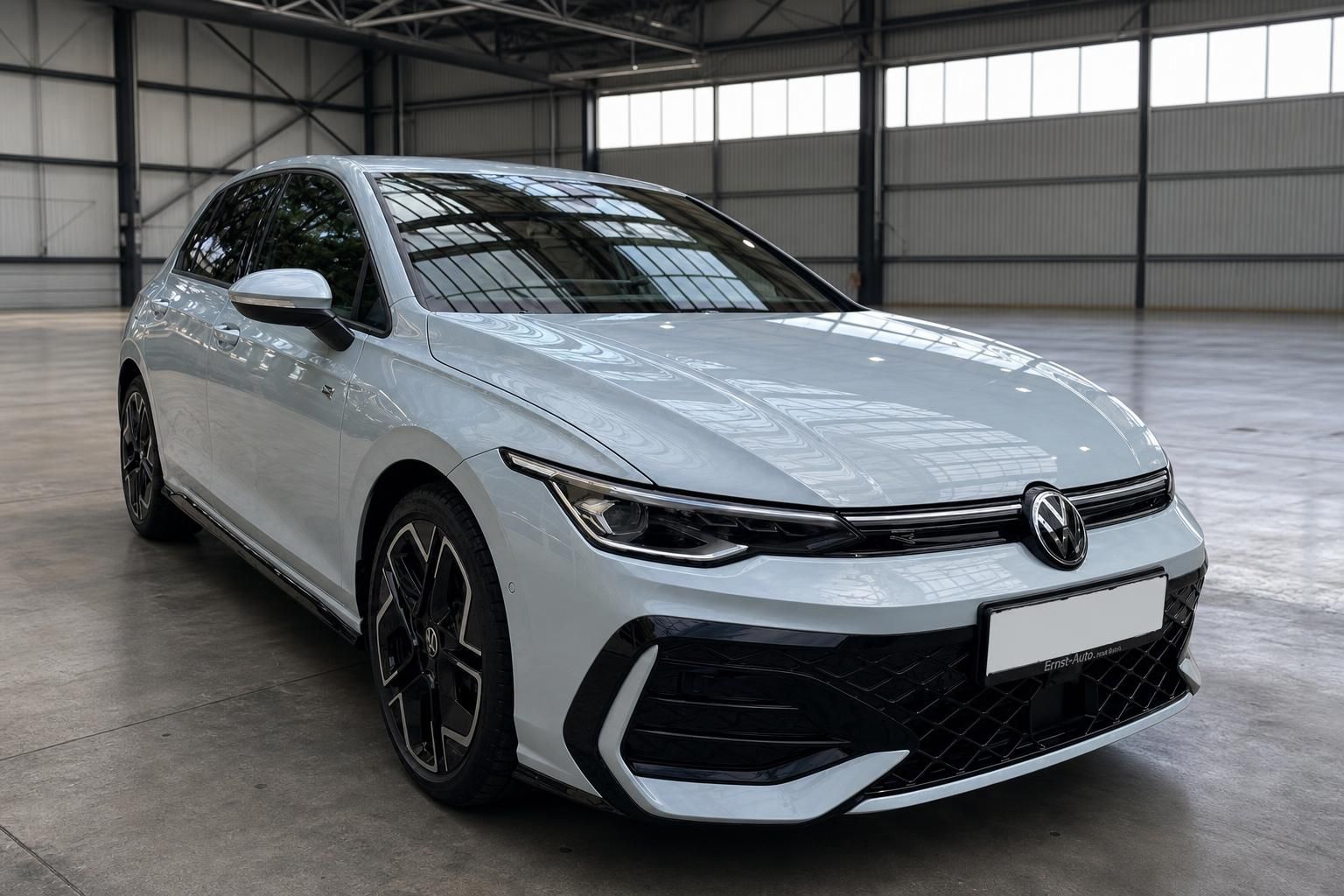 Volkswagen Golf weiss Frontansicht schraeg in Flugzeughalle - Kompaktwagen mit Sportbumper