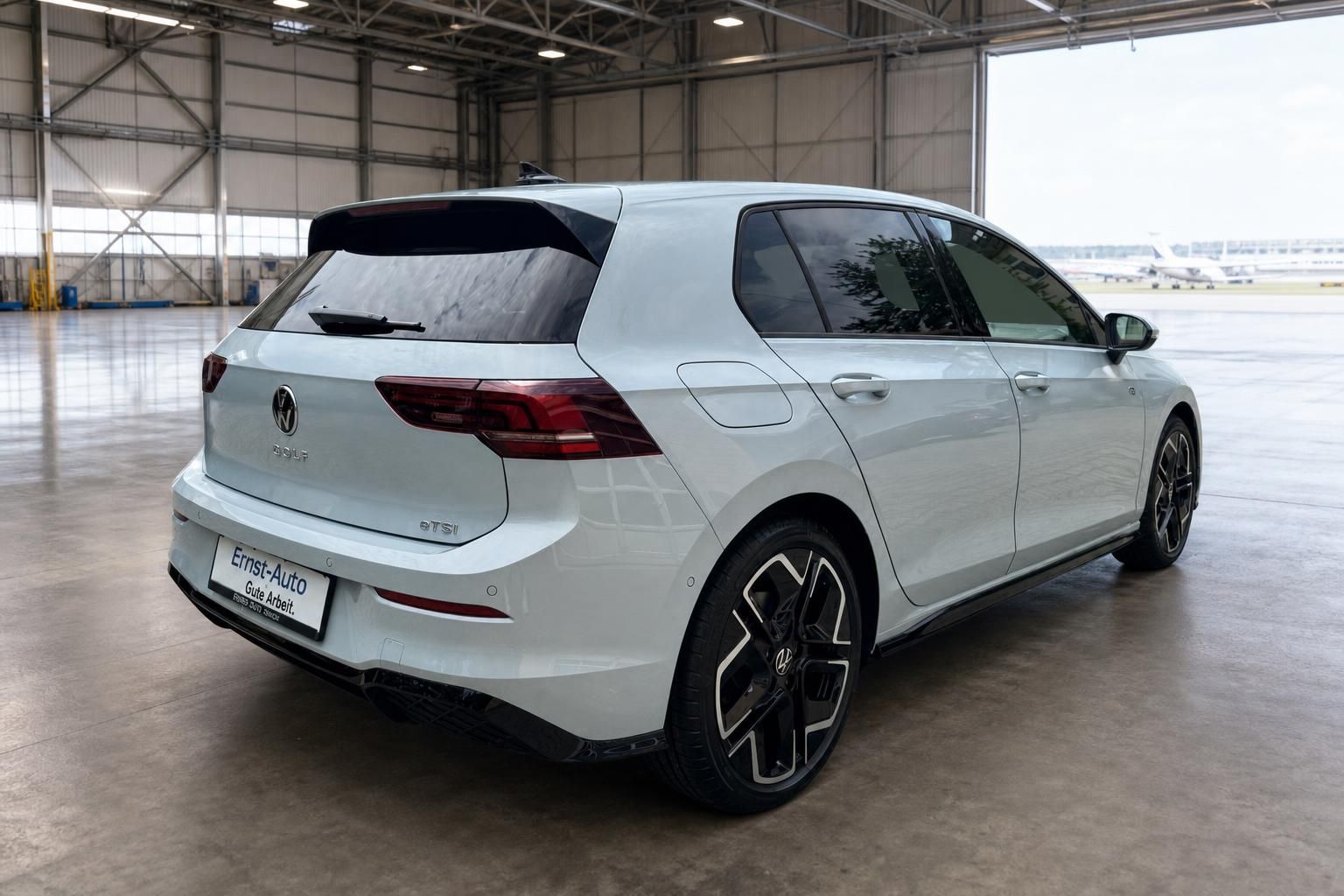 Volkswagen Golf weiss Heckansicht mit eTSI Motor in Flugzeughalle - Kompaktklasse Fahrzeug