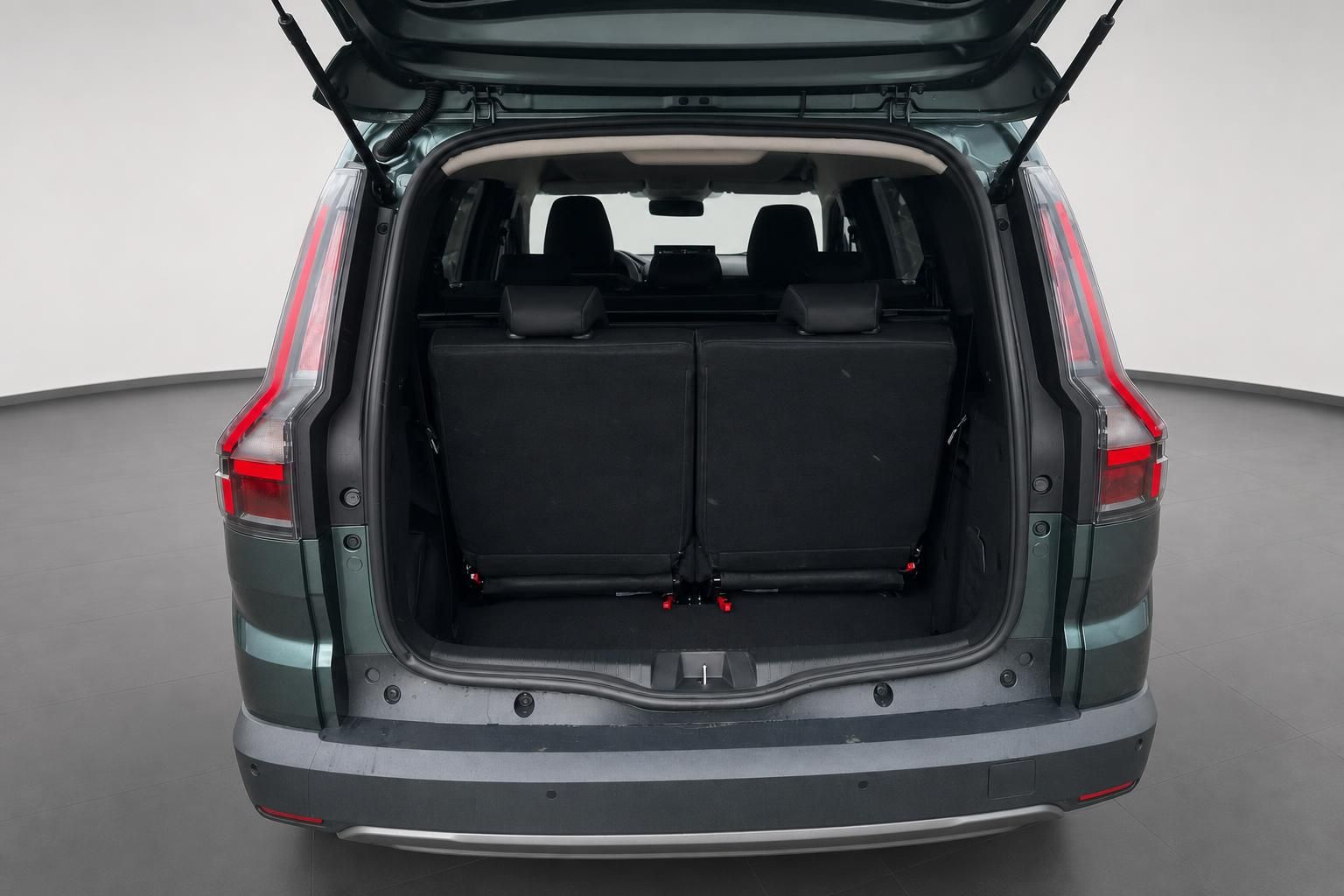 Kofferraum eines grünen SUVs mit geöffneter Heckklappe und schwarzer Innenausstattung