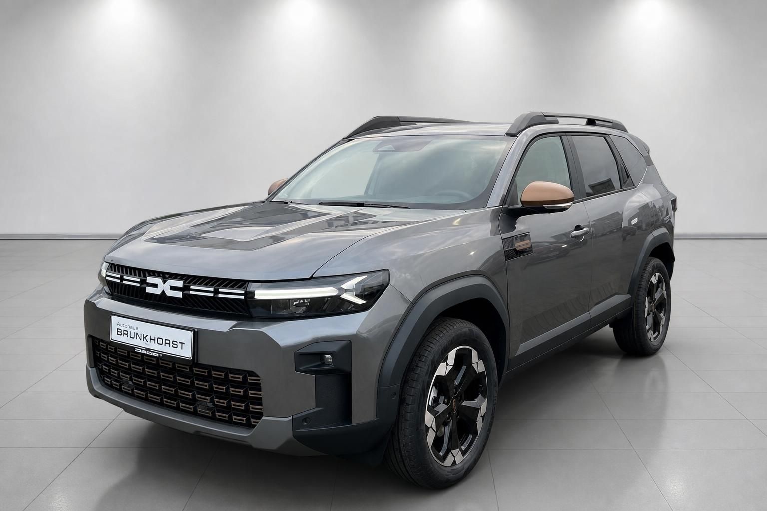Dacia Bigster grauer SUV Seitenansicht - sportliches Design mit Dachreling und Allradfelgen