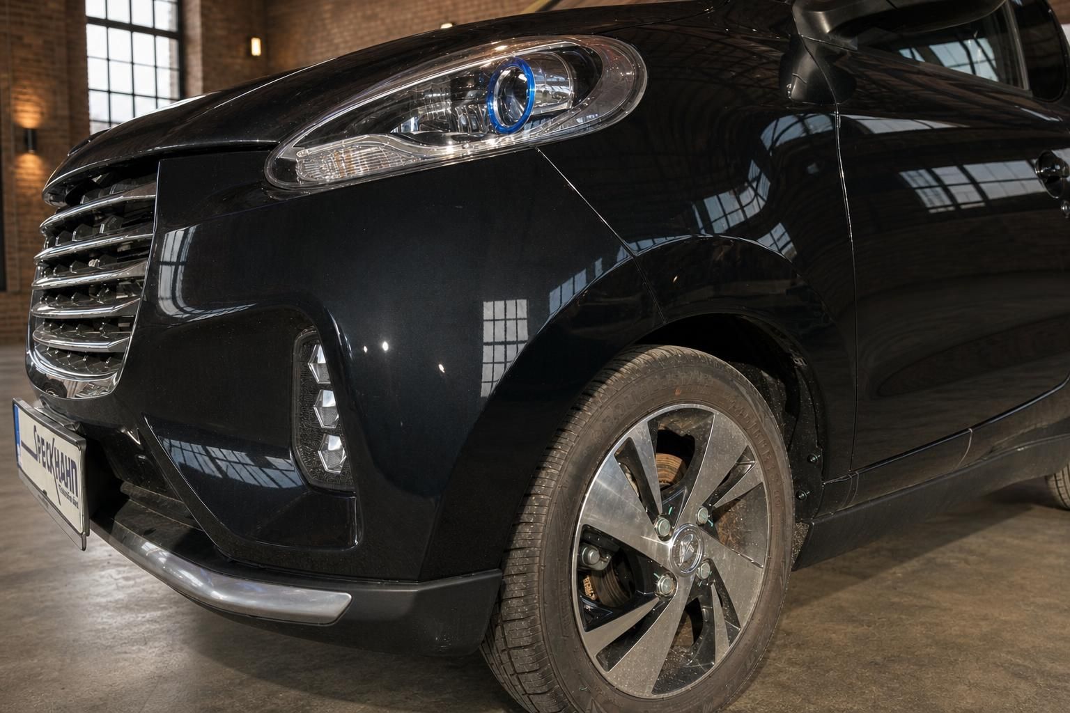 Elaris Elektroauto schwarz Detailansicht Front mit LED-Tagfahrlicht und Alufelge