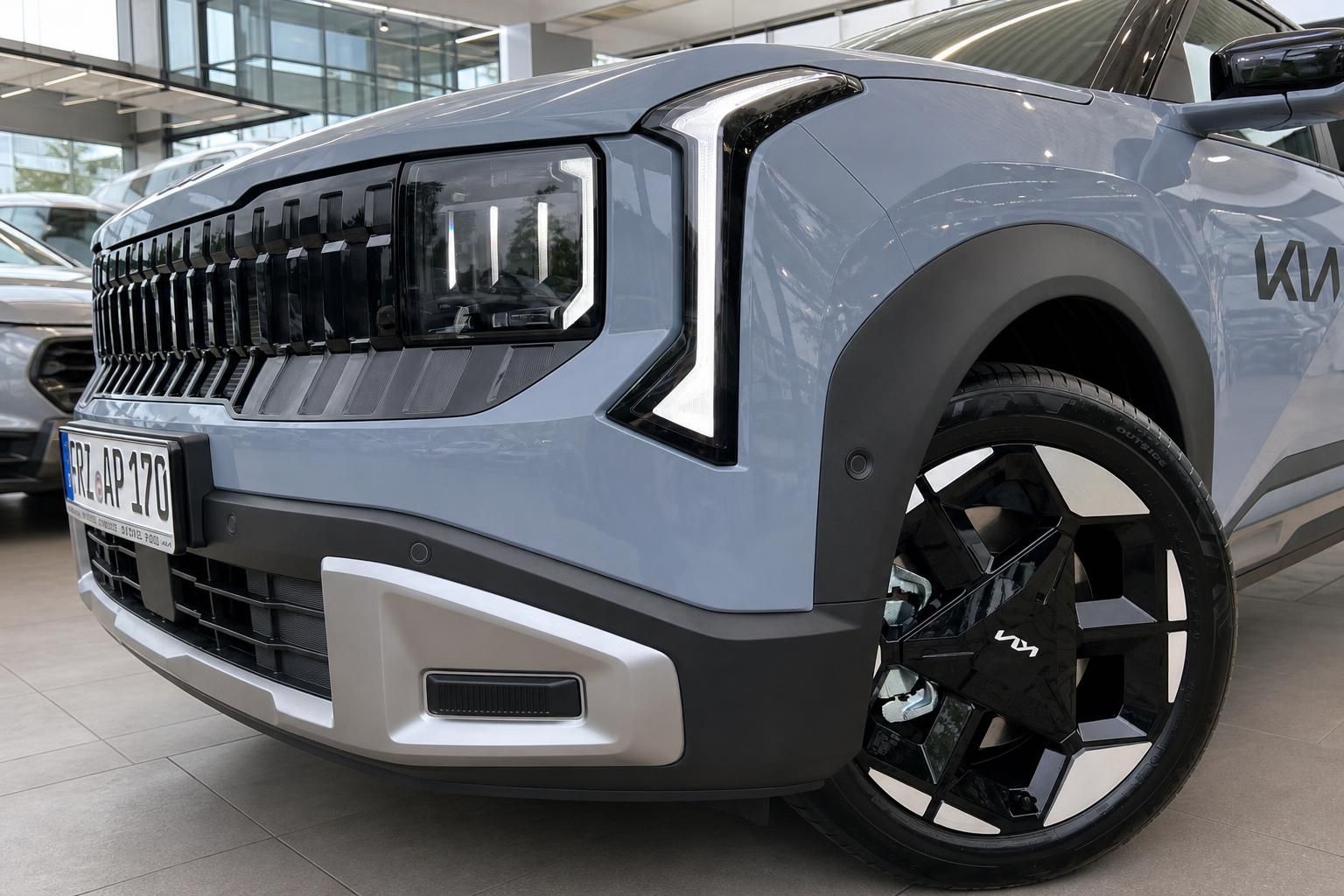 Kia SUV in Blaugrau: Frontpartie mit LED-Scheinwerfer und Felge im Detail