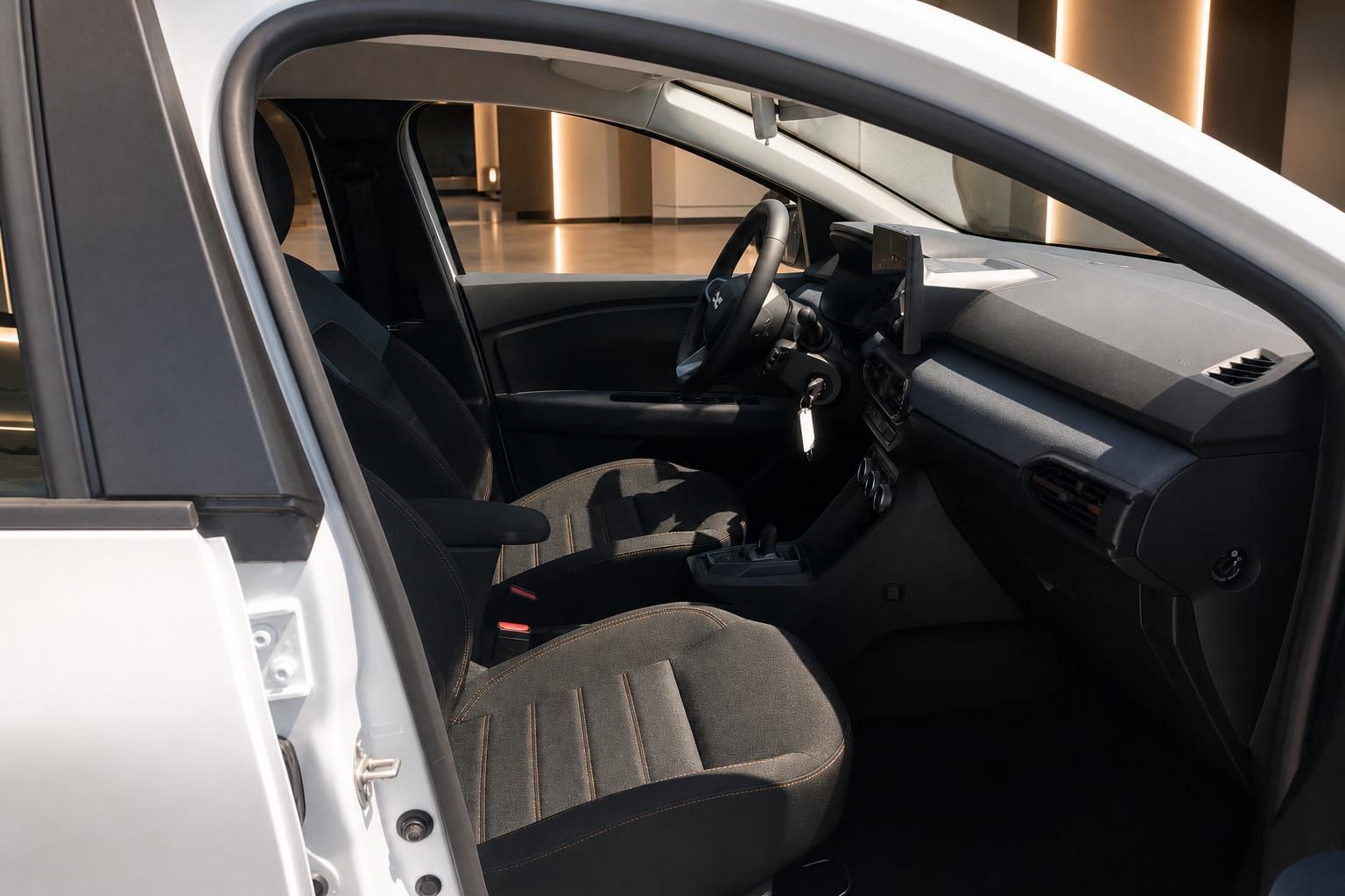 Dacia Innenraum Fahrerseite mit Vordersitzen, Lenkrad und Mittelkonsole im Autohaus