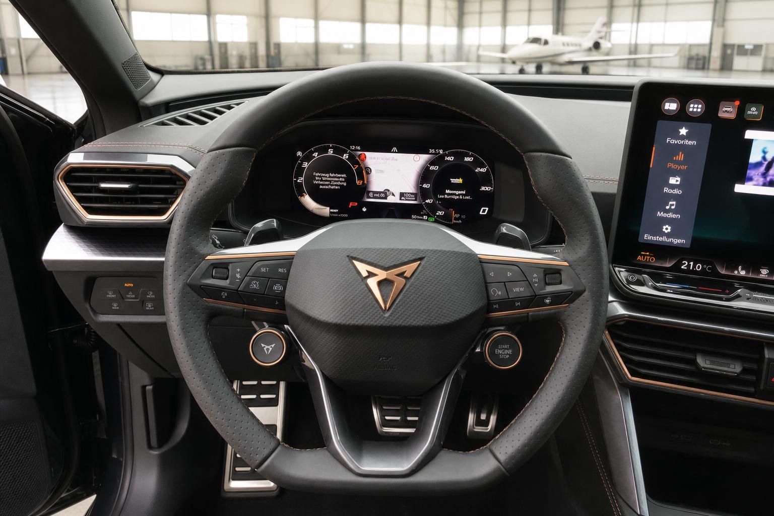 Fahrzeug-Cockpit mit perforiertem Lenkrad und digitalen Armaturen