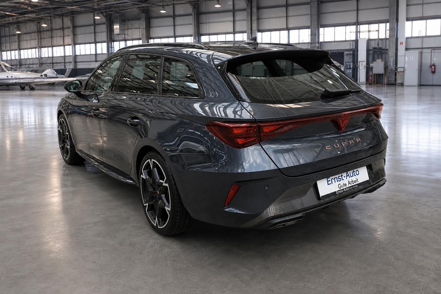 Cupra Leon Kombi Heckansicht grau mit Händlerschild Ernst-Auto in Hangar