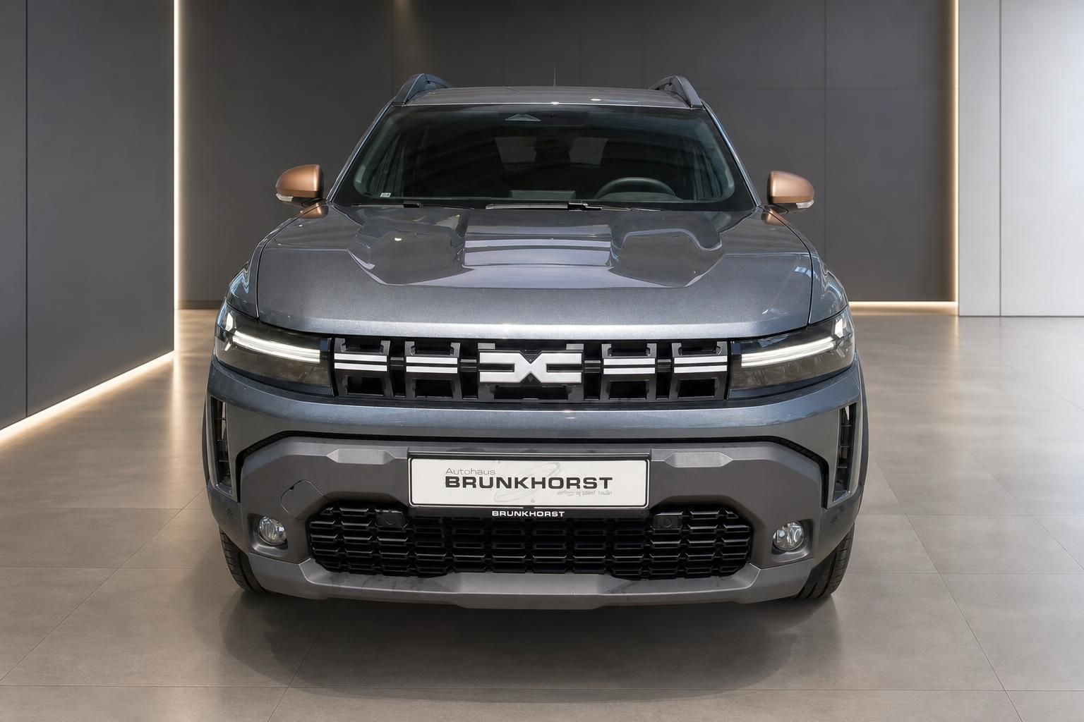 Dacia Duster grau Frontansicht im Showroom – neues Modell mit charakteristischem Kühlergrill