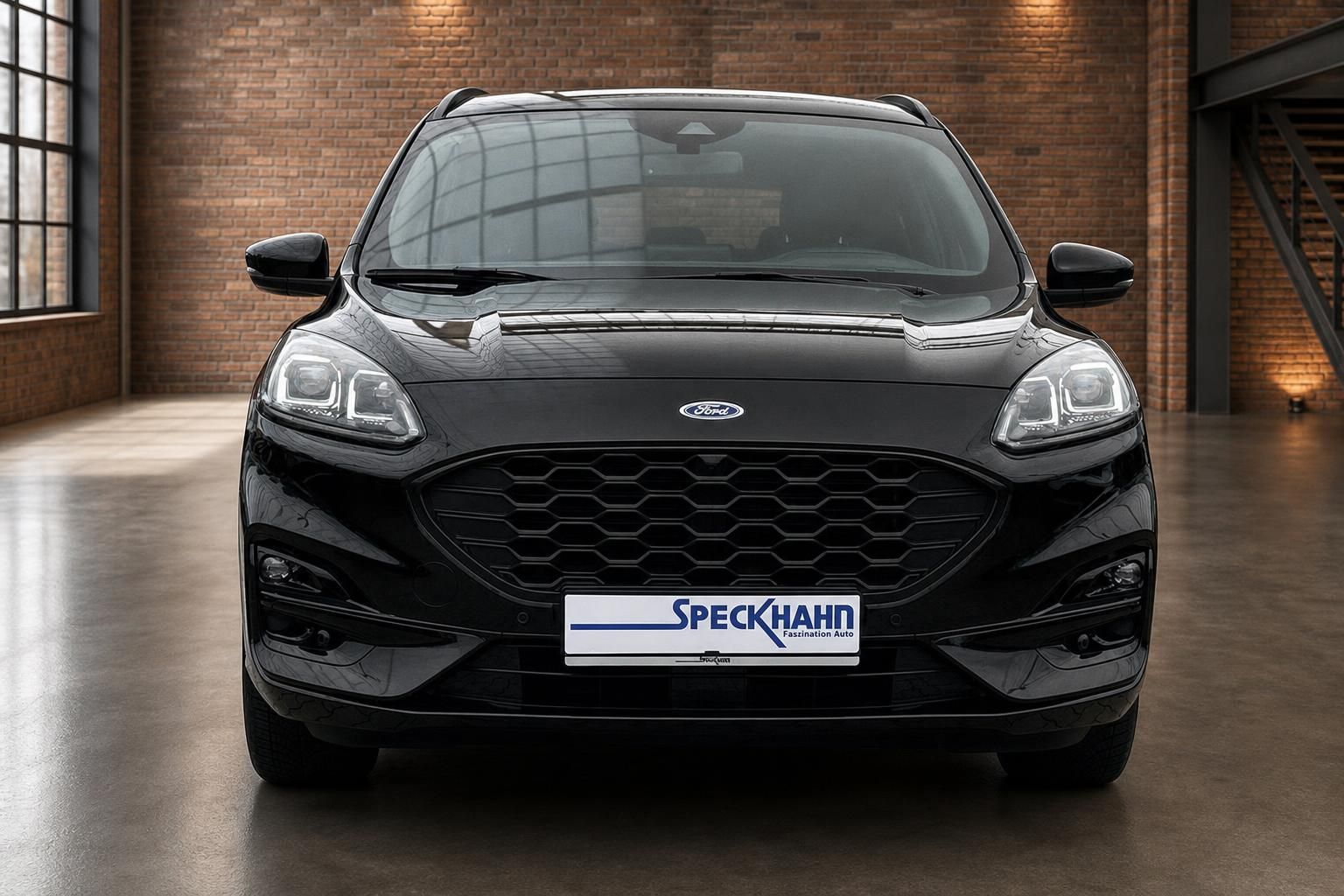 Ford Kuga schwarz Frontansicht in moderner Halle mit Backsteinmauer