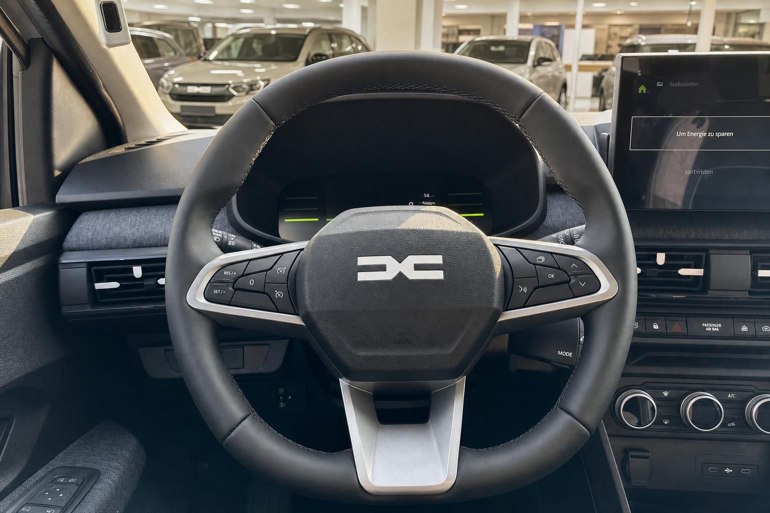 Fahrzeug Innenraum mit schwarzem Lenkrad und Infotainment-Display im Autohaus Showroom