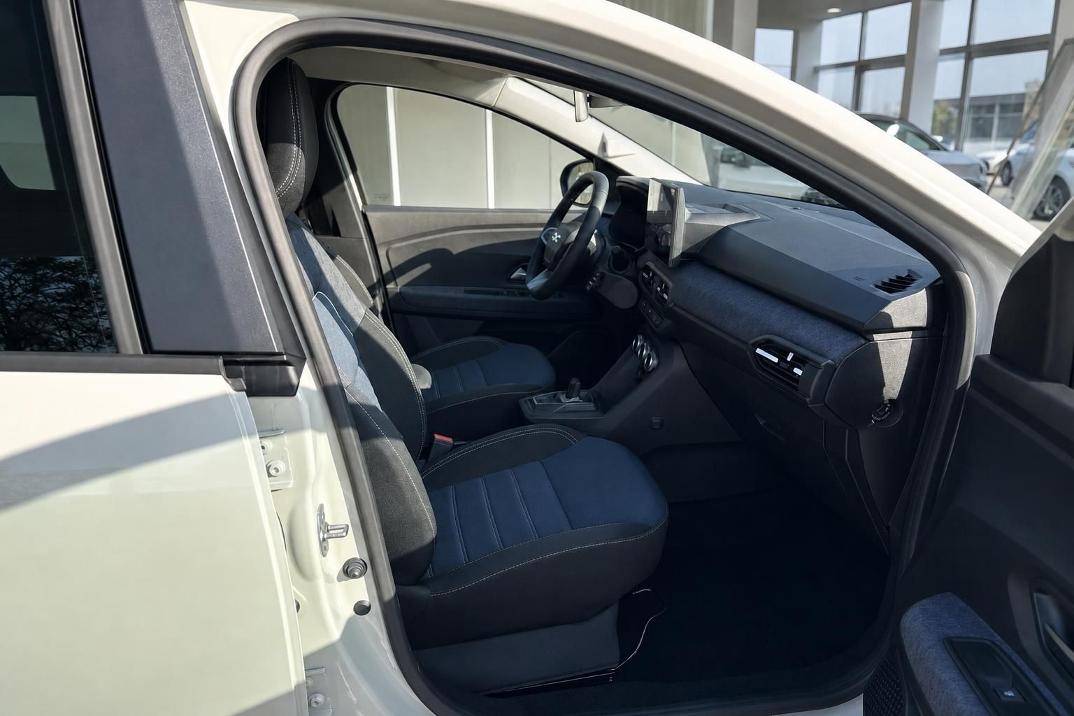 Fahrzeuginnenraum mit schwarzen Sitzen und modernem Armaturenbrett im Autohaus-Showroom