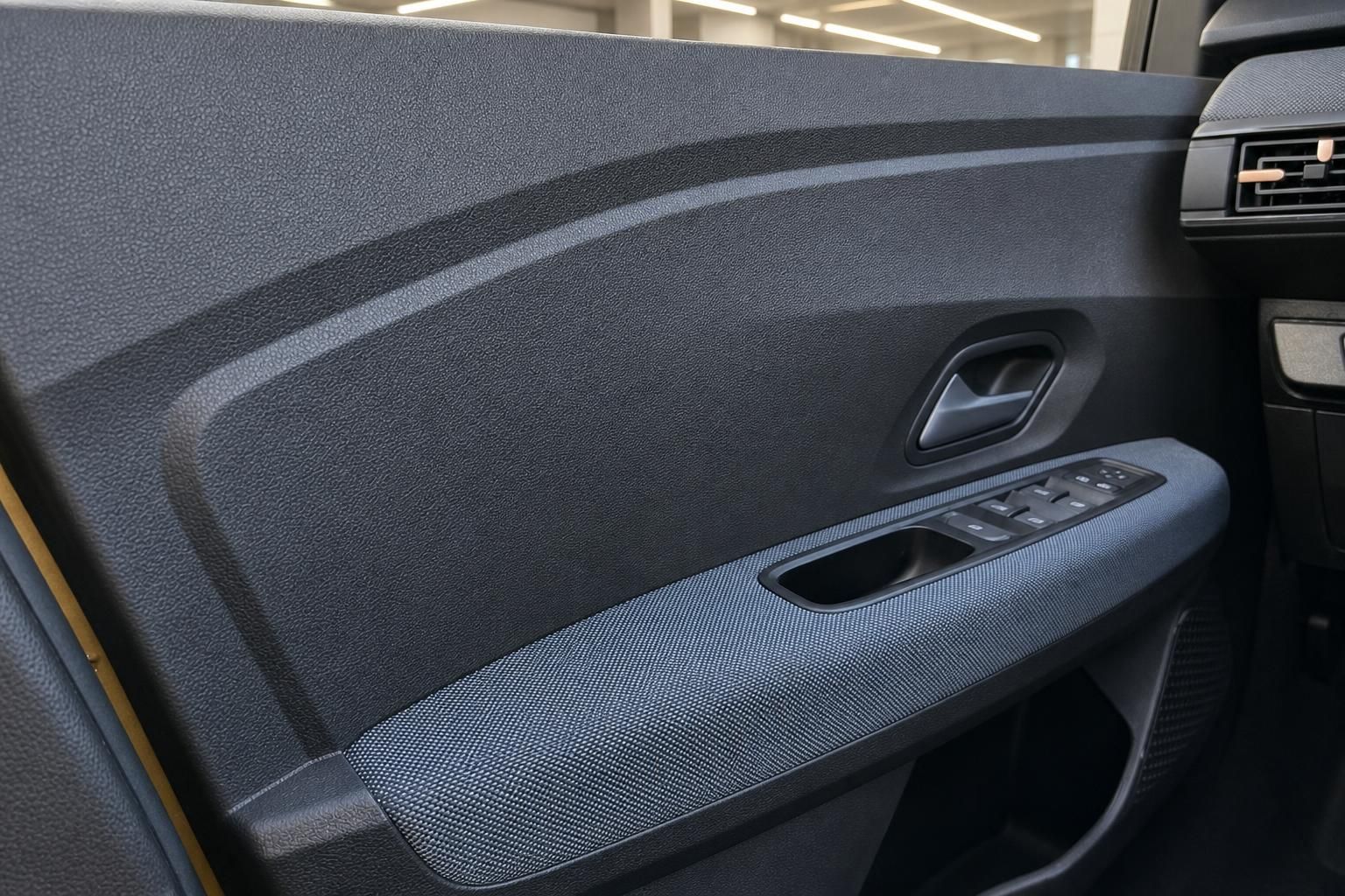 Fahrzeugtürverkleidung in Grau mit Fensterheber-Bedienung und Türgriff-Details
