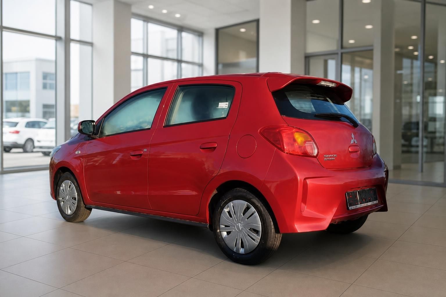 Roter Mitsubishi Space Star Heckansicht mit Spoiler im modernen Autohaus
