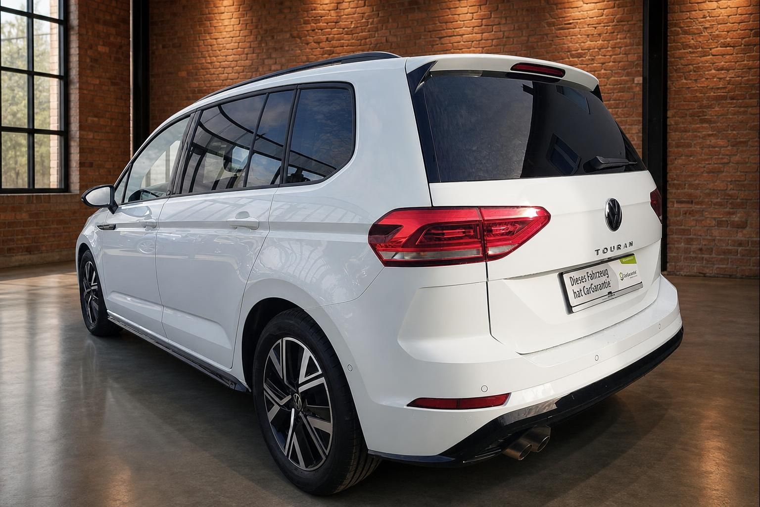 VW Touran weiß Heckansicht seitlich mit Panoramadach in Halle
