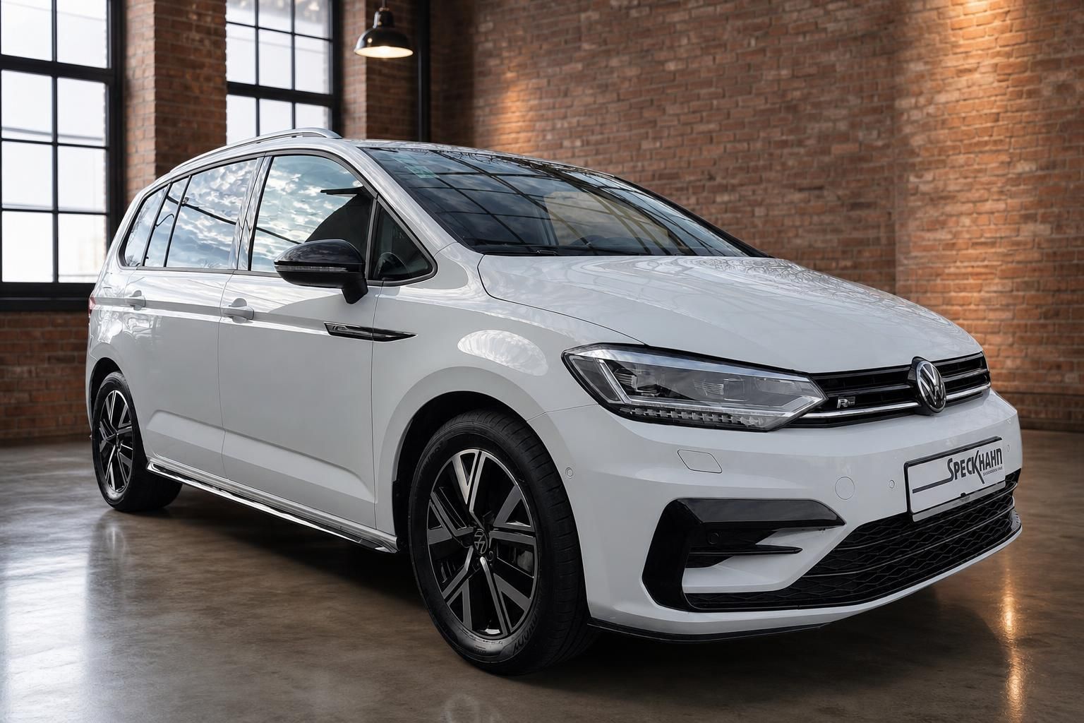 VW Touran R-Line weiß Frontansicht in Loft-Halle mit Backsteinwand