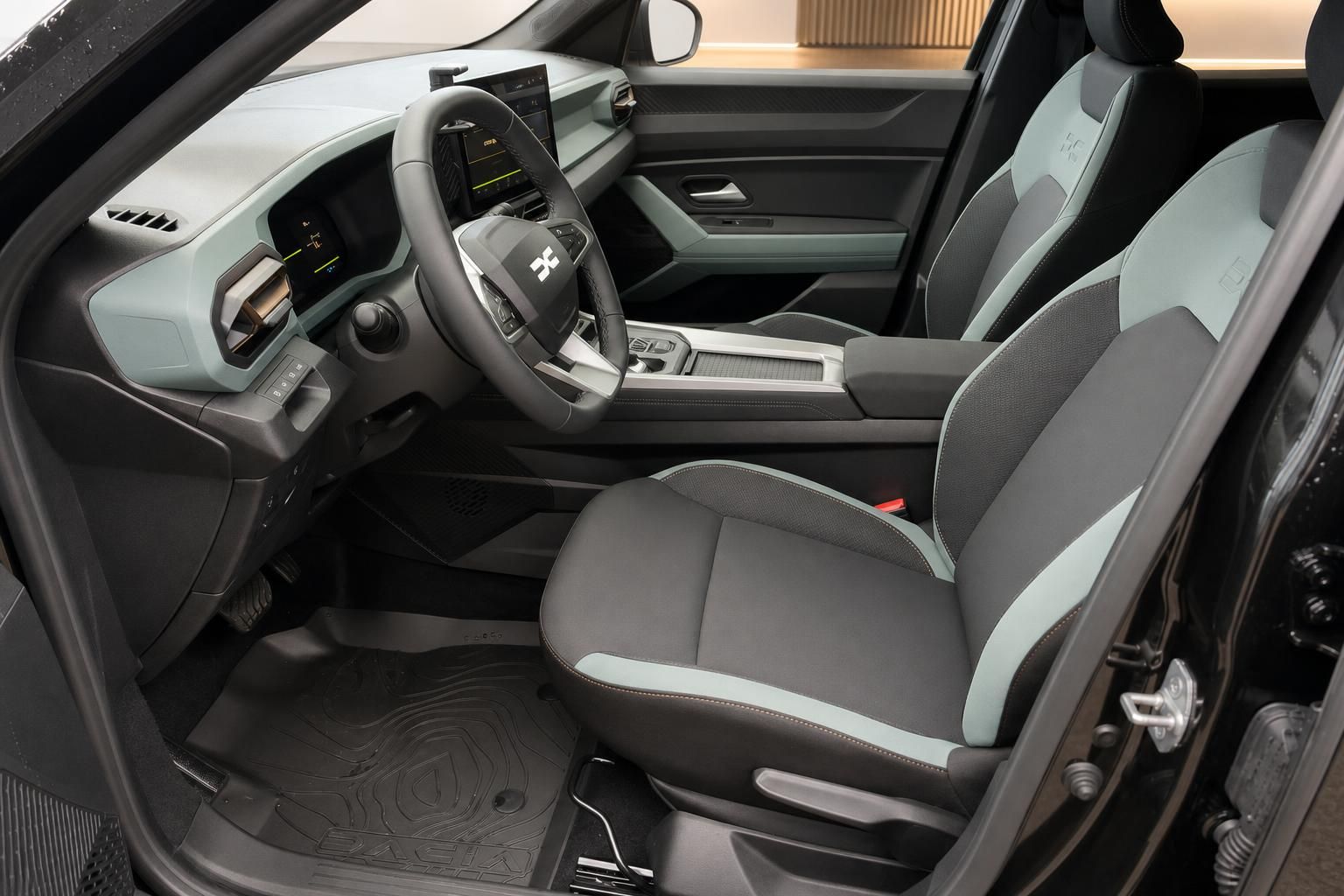Dacia Innenraum Fahrerseite – Cockpit mit Lenkrad, Digitalanzeige und mintfarbenen Sitzen