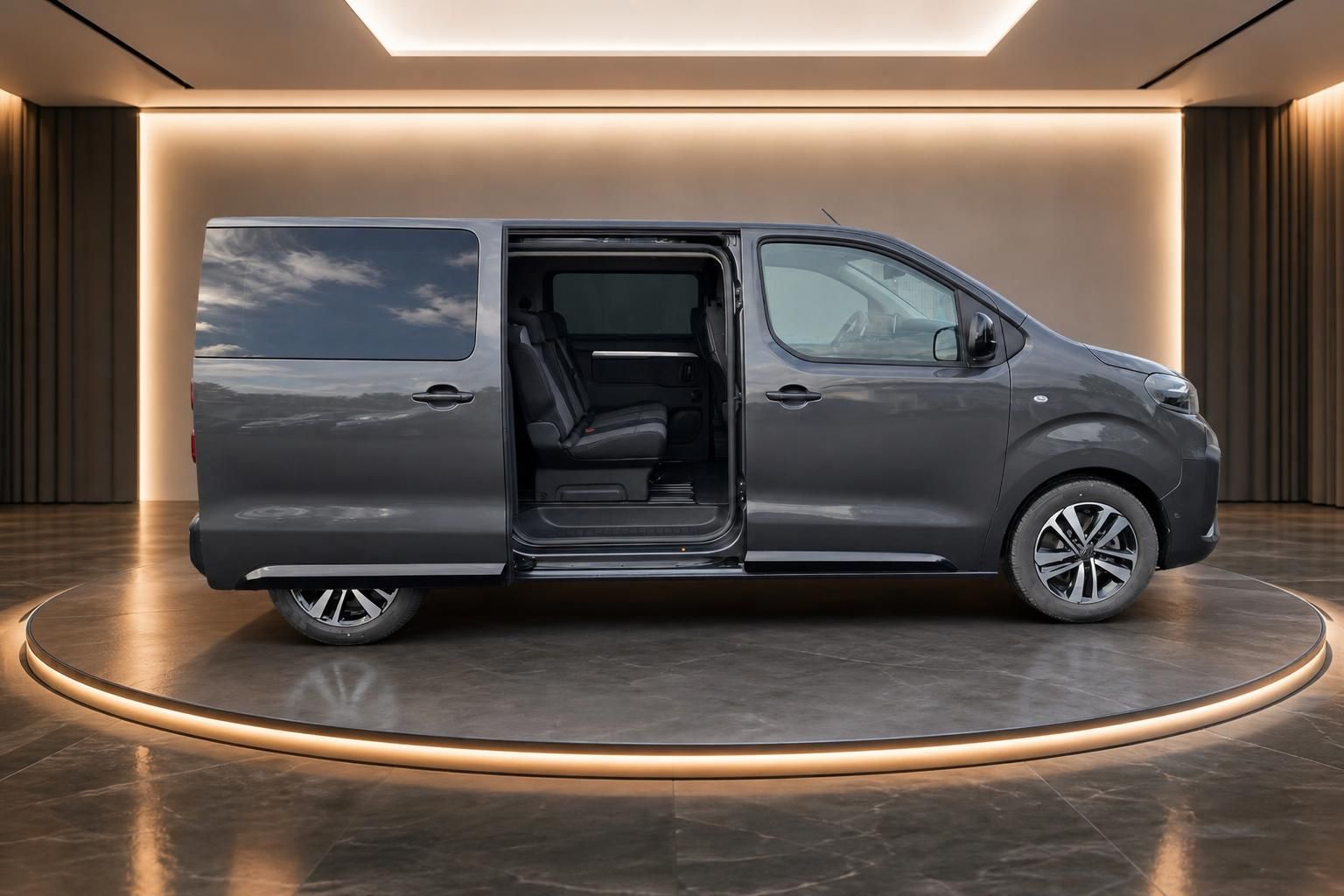Grauer Van mit offener Seitentür in modernem Showroom - Seitenansicht links