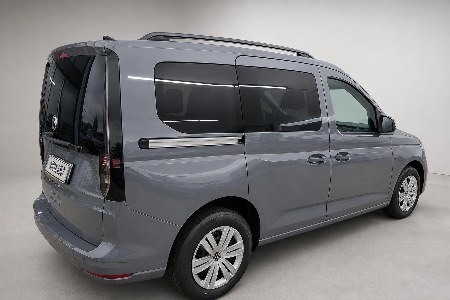 VW Caddy grau Seitenansicht schraeg von hinten mit Dachreling