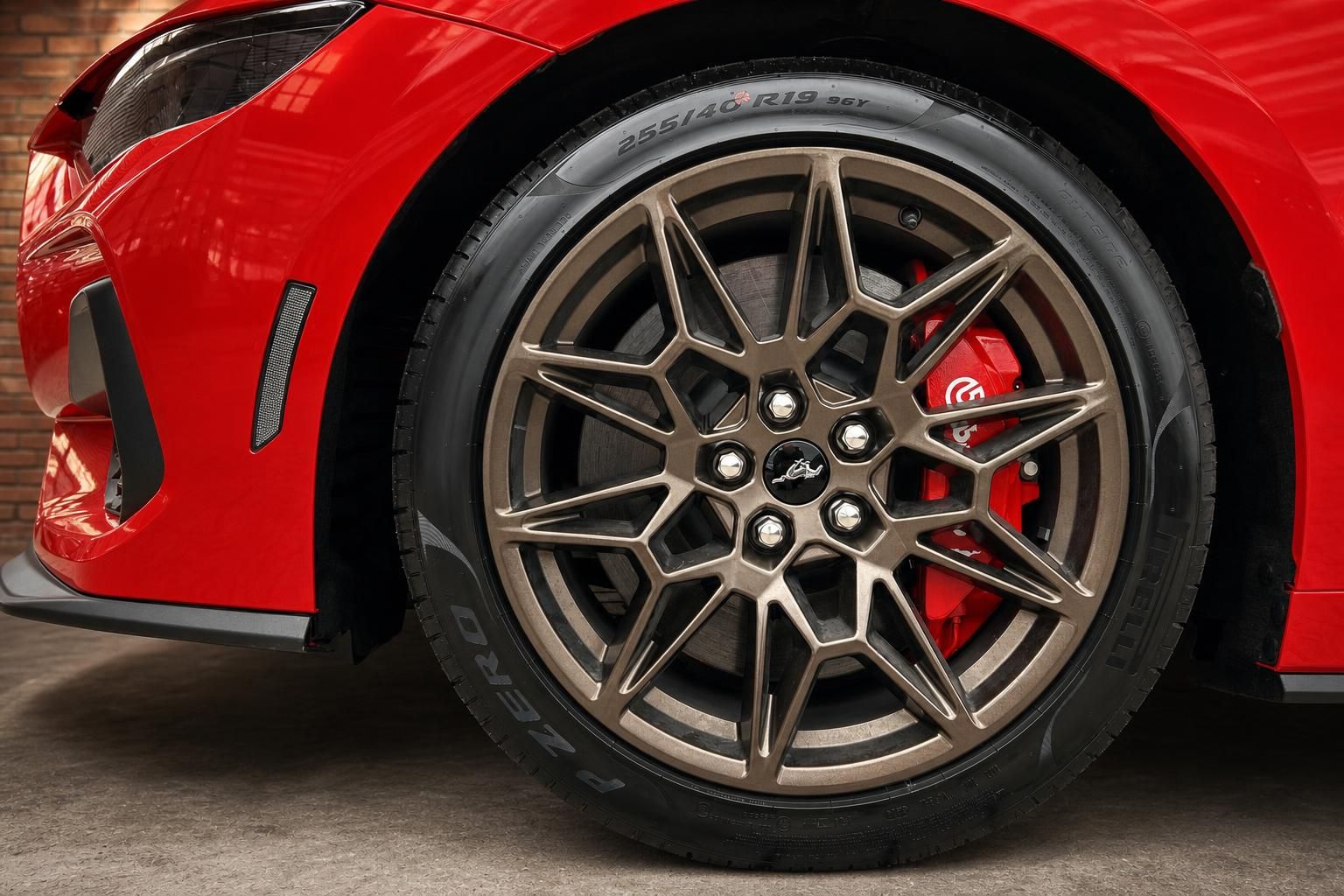 Detailansicht Leichtmetallfelge und rote Bremssattel des roten Ford Mustang