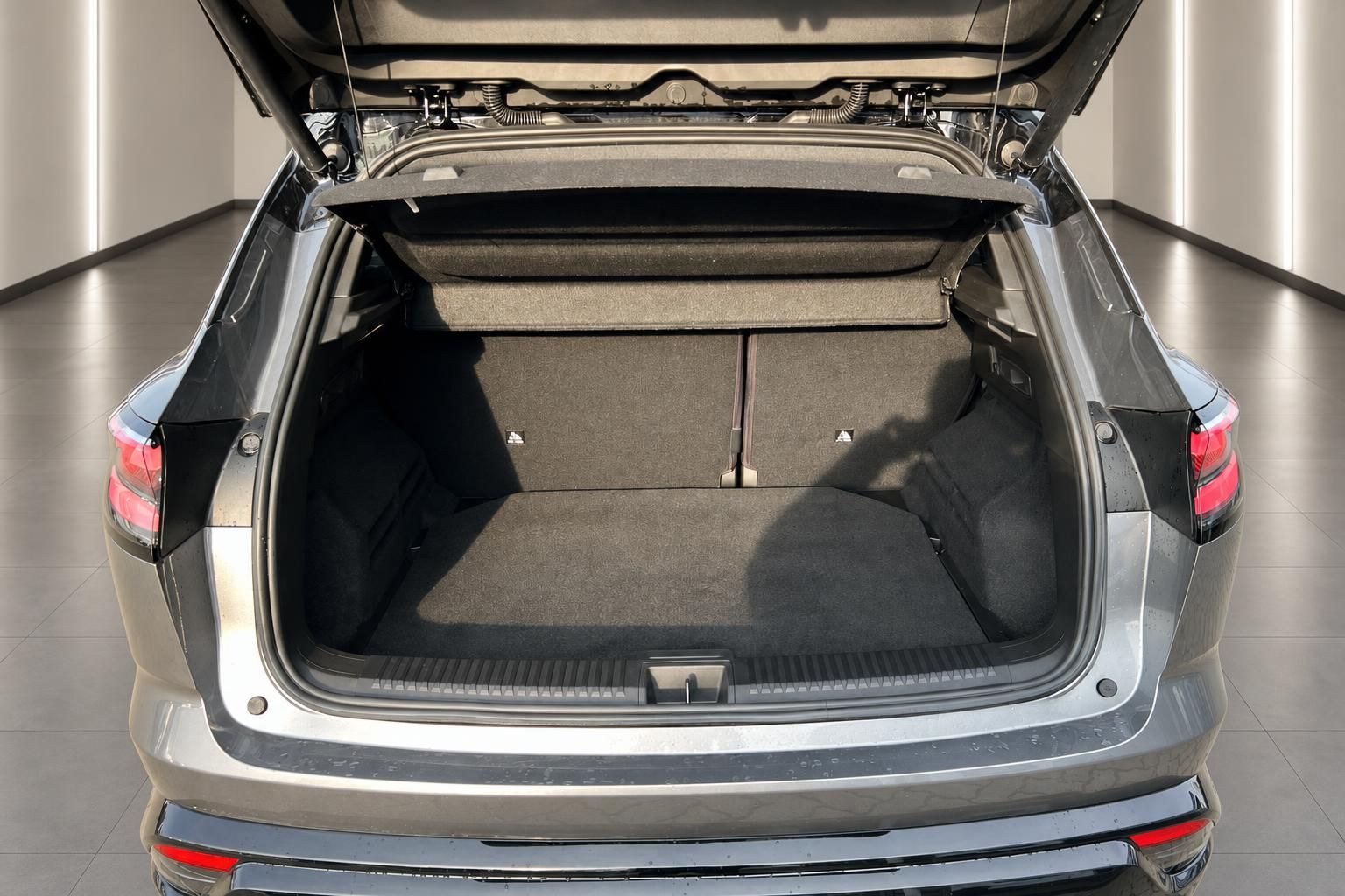 Kofferraum eines silbernen SUV mit geöffneter Heckklappe und grauem Innenraum