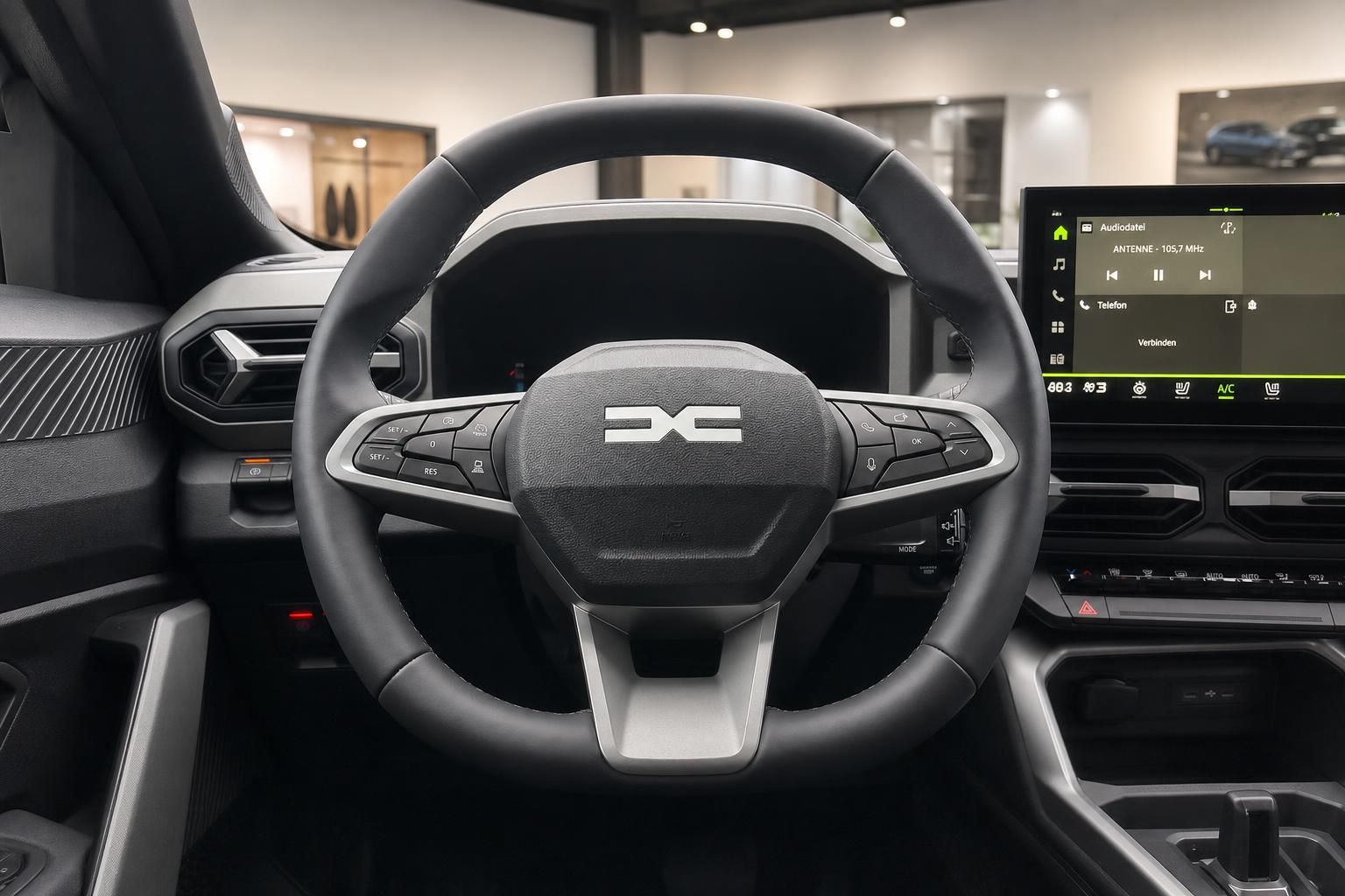 Dacia Innenraum Lenkrad mit Logo und Touchscreen-Infotainmentsystem in der Fahrerkabine