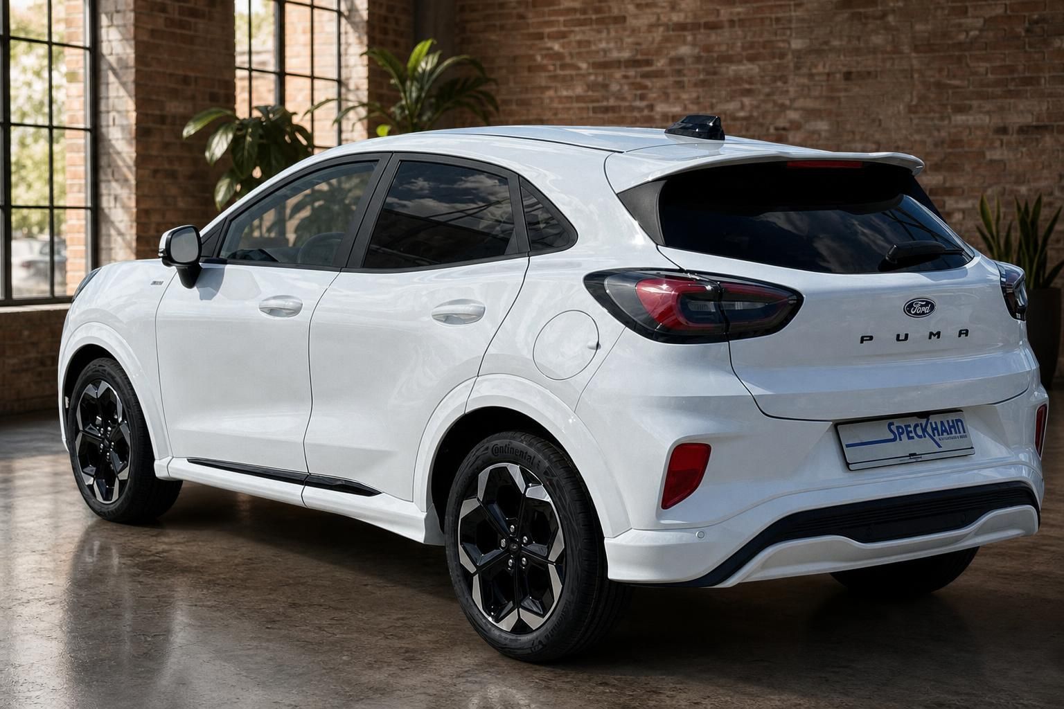 Ford Puma weiss Heckansicht seitlich in moderner Showroom-Halle