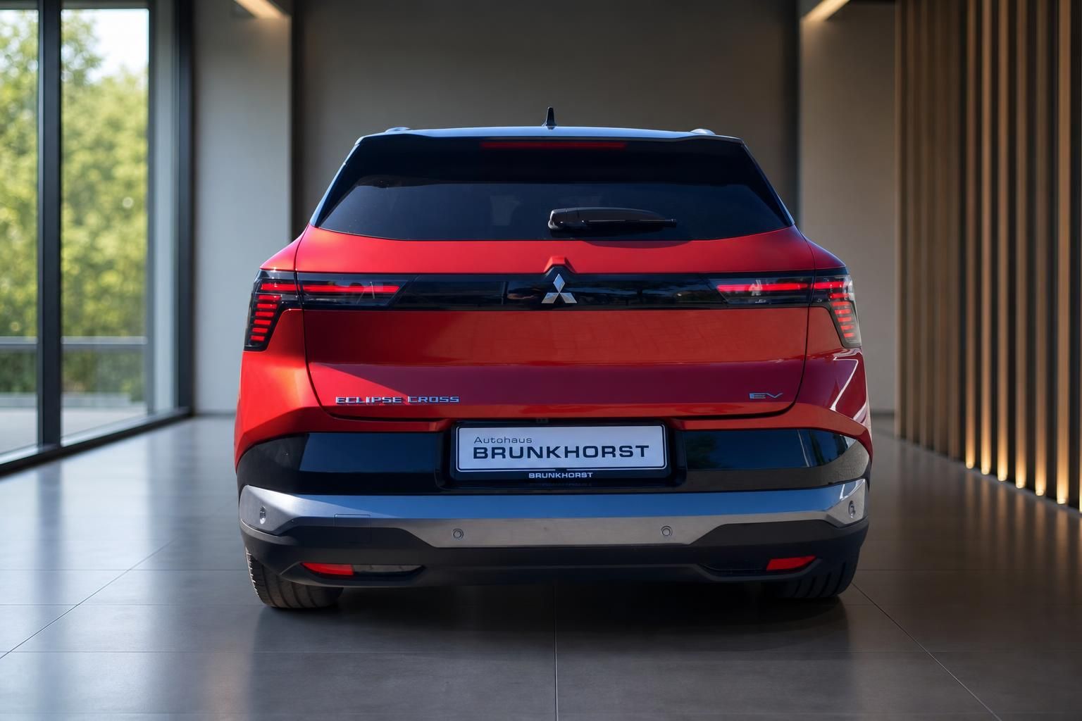 Mitsubishi Eclipse Cross EV Heckansicht in rot mit schwarzem Dach im modernen Showroom