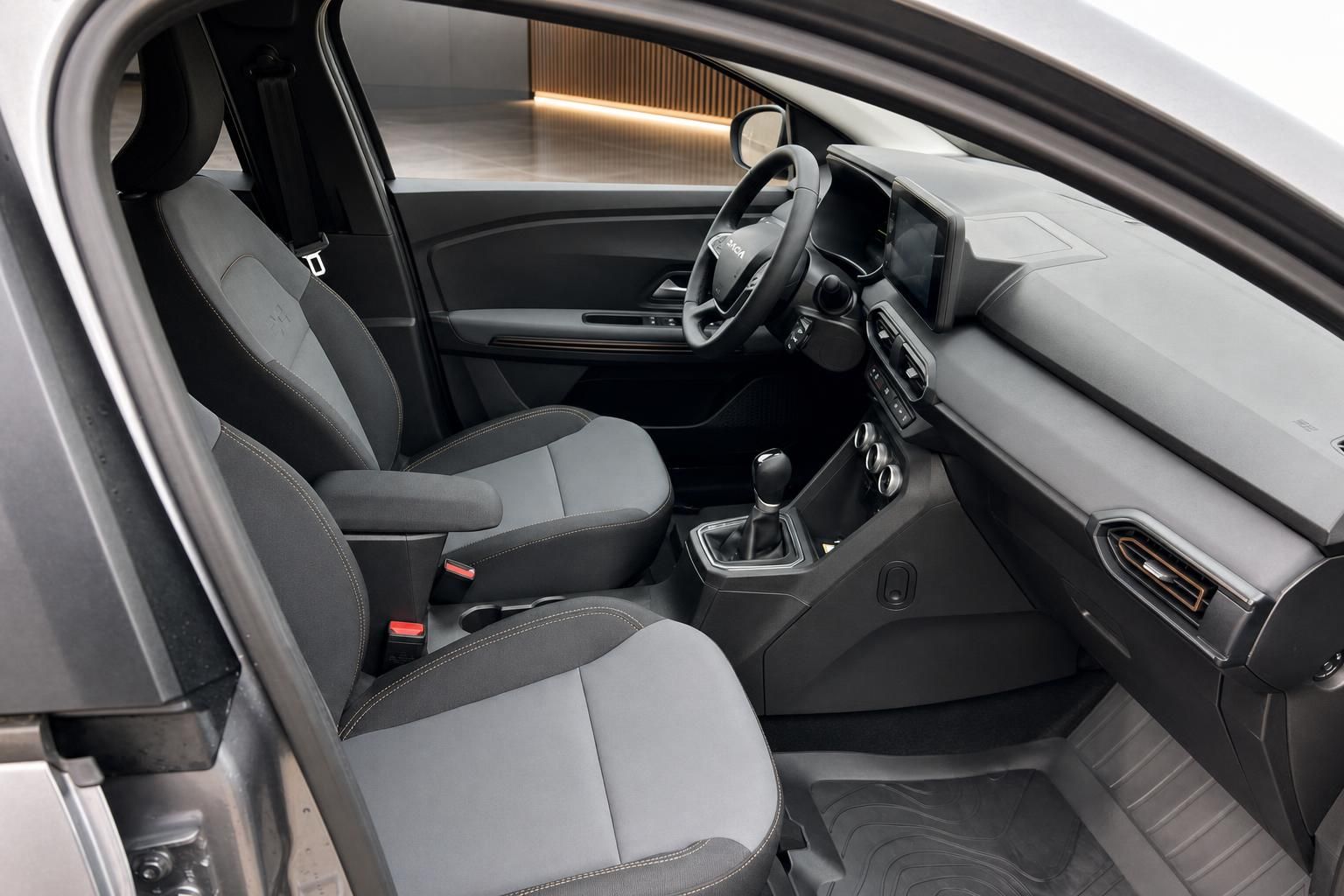 Dacia Fahrzeuginnenraum mit grauen Sitzen, Schaltgetriebe und modernem Interieur Design