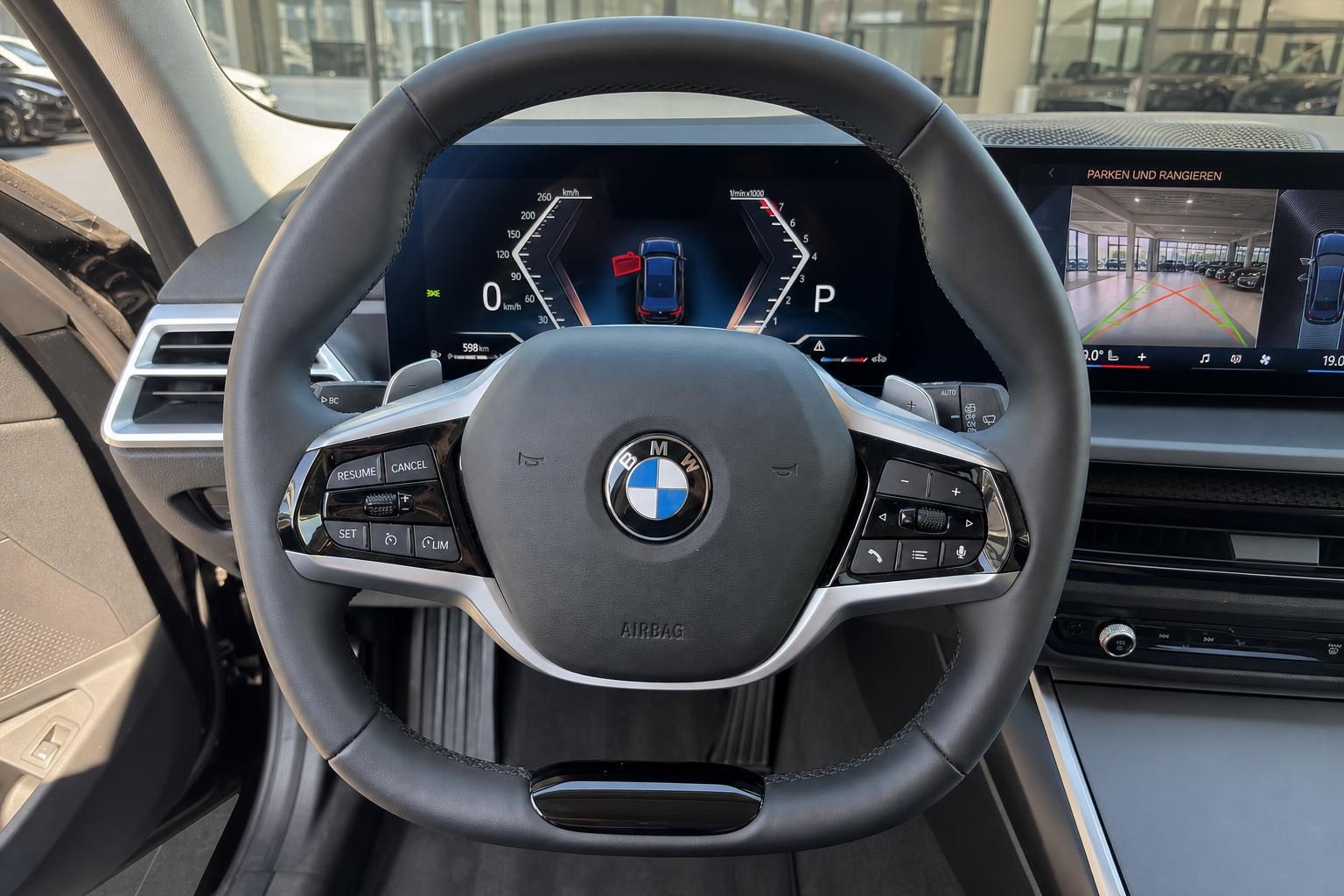 BMW Lenkrad Nahaufnahme mit Tacho und Parkassistent-Display