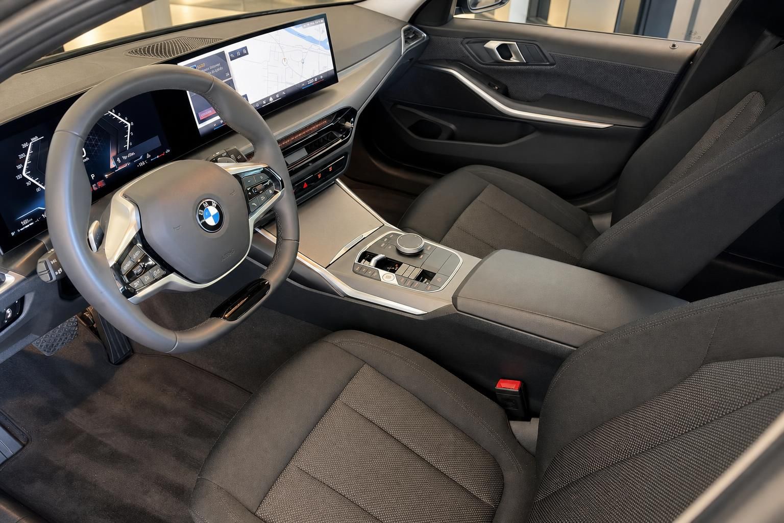 BMW Innenraum mit Lenkrad, Cockpit-Display und schwarzen Sportsitzen