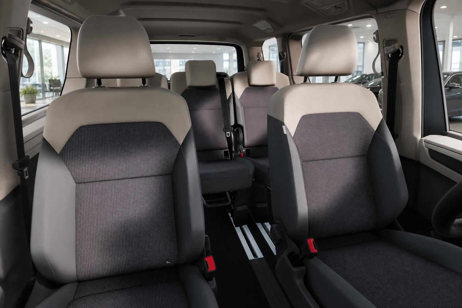VW Multivan Innenraum mit mehrreihigen Sitzen in Grau-Beige und Sicherheitsgurten