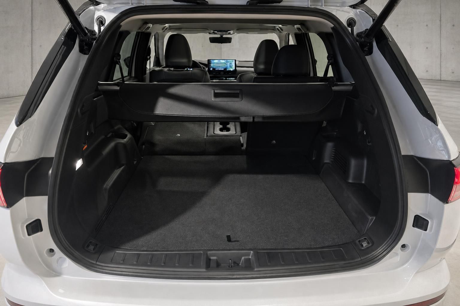 Kofferraum eines weißen SUV mit umgeklappten Rücksitzen und viel Stauraum