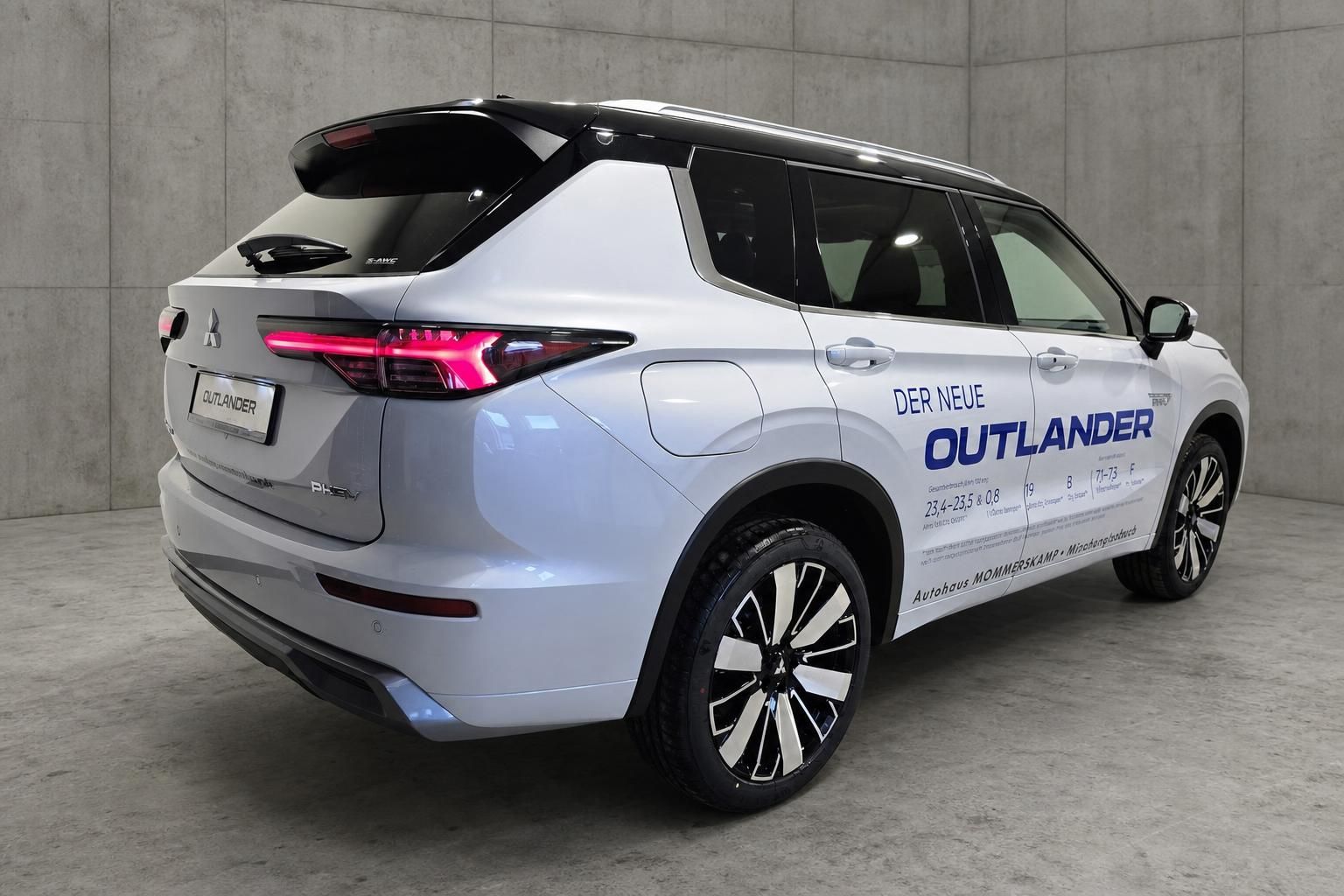 Mitsubishi Outlander PHEV silber, Heckansicht schraeg mit Ruecklichtern