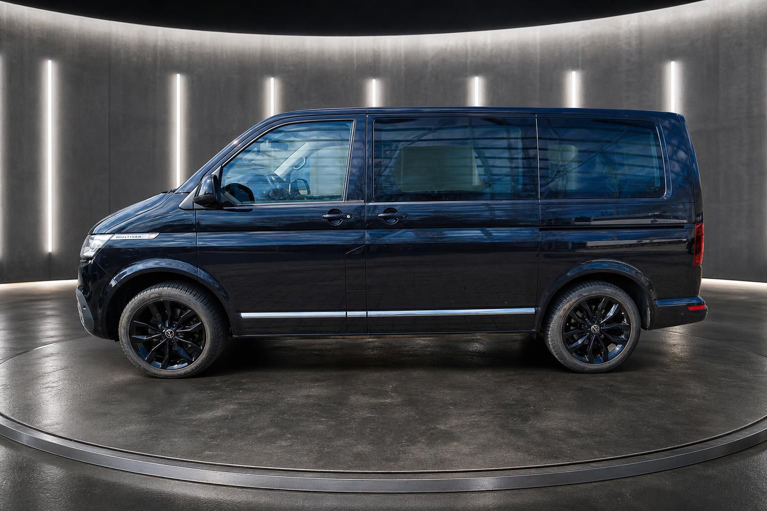 VW Multivan dunkelblau Seitenansicht mit Alufelgen im Showroom