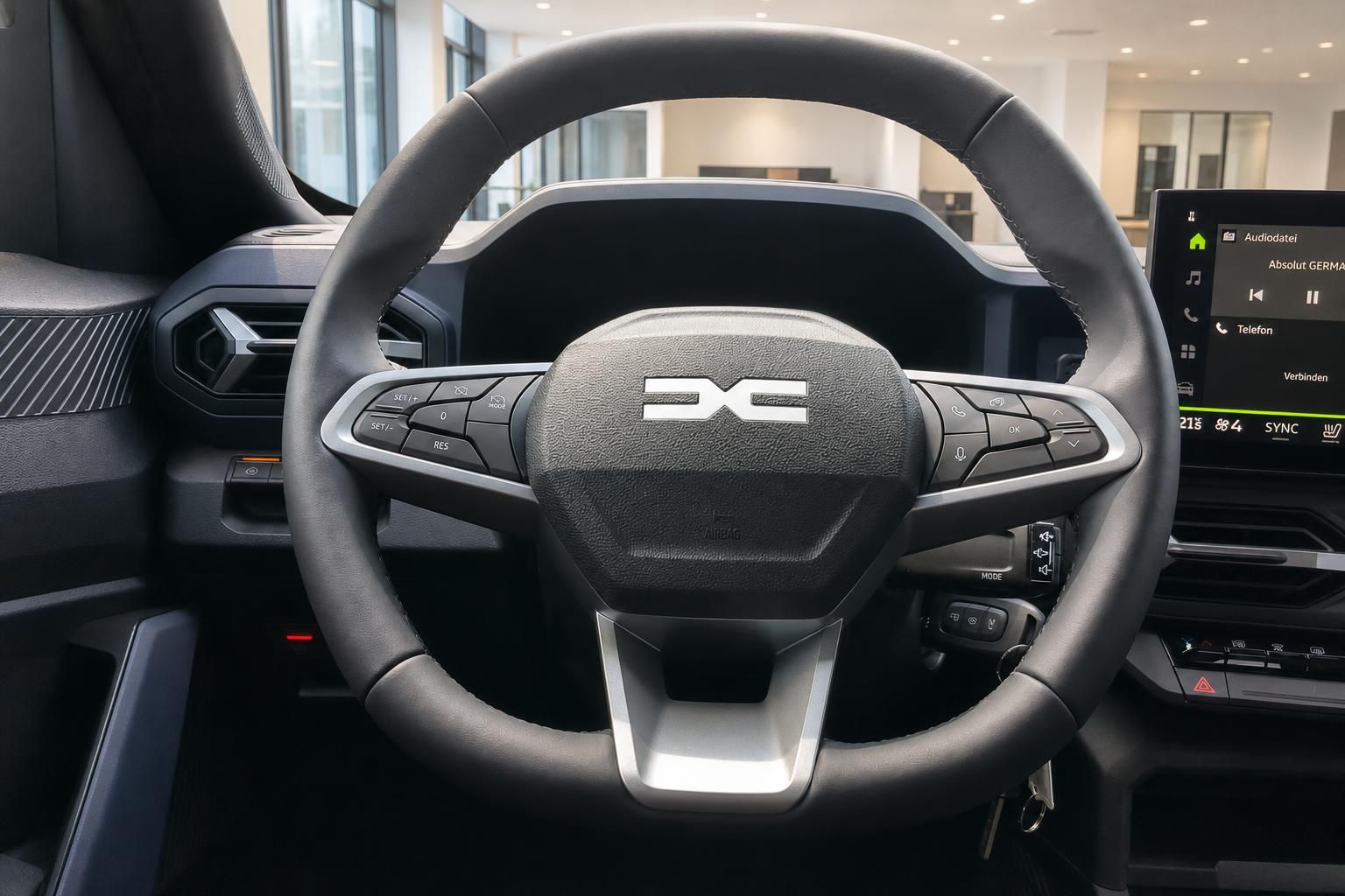 Lenkrad mit Multifunktionstasten und Infotainment-Display im Cockpit